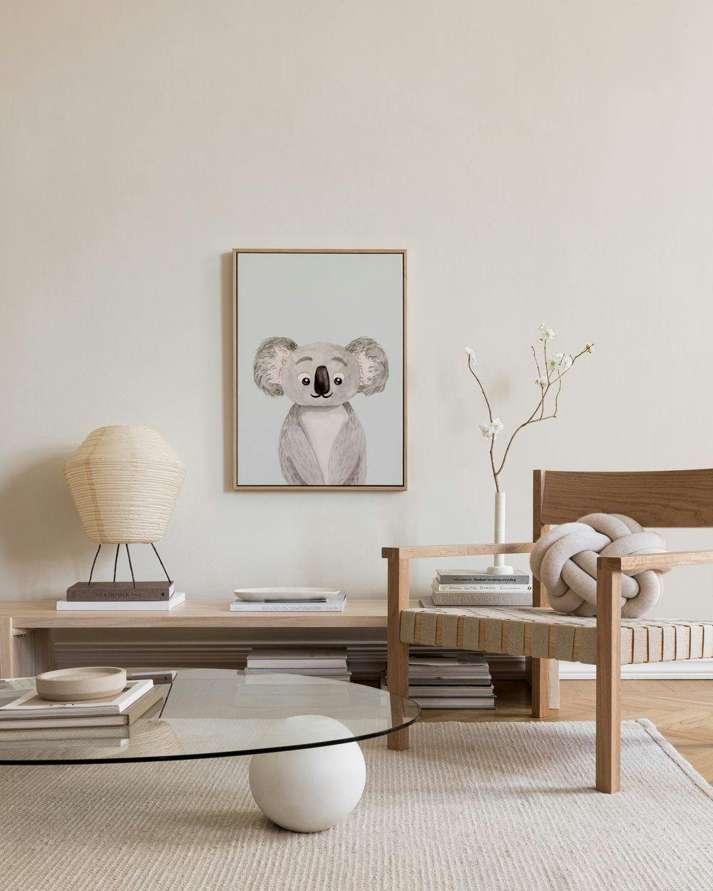 Lerretsbilde med en grå koala på lyseblå bakgrunn, henger i en lys stue.