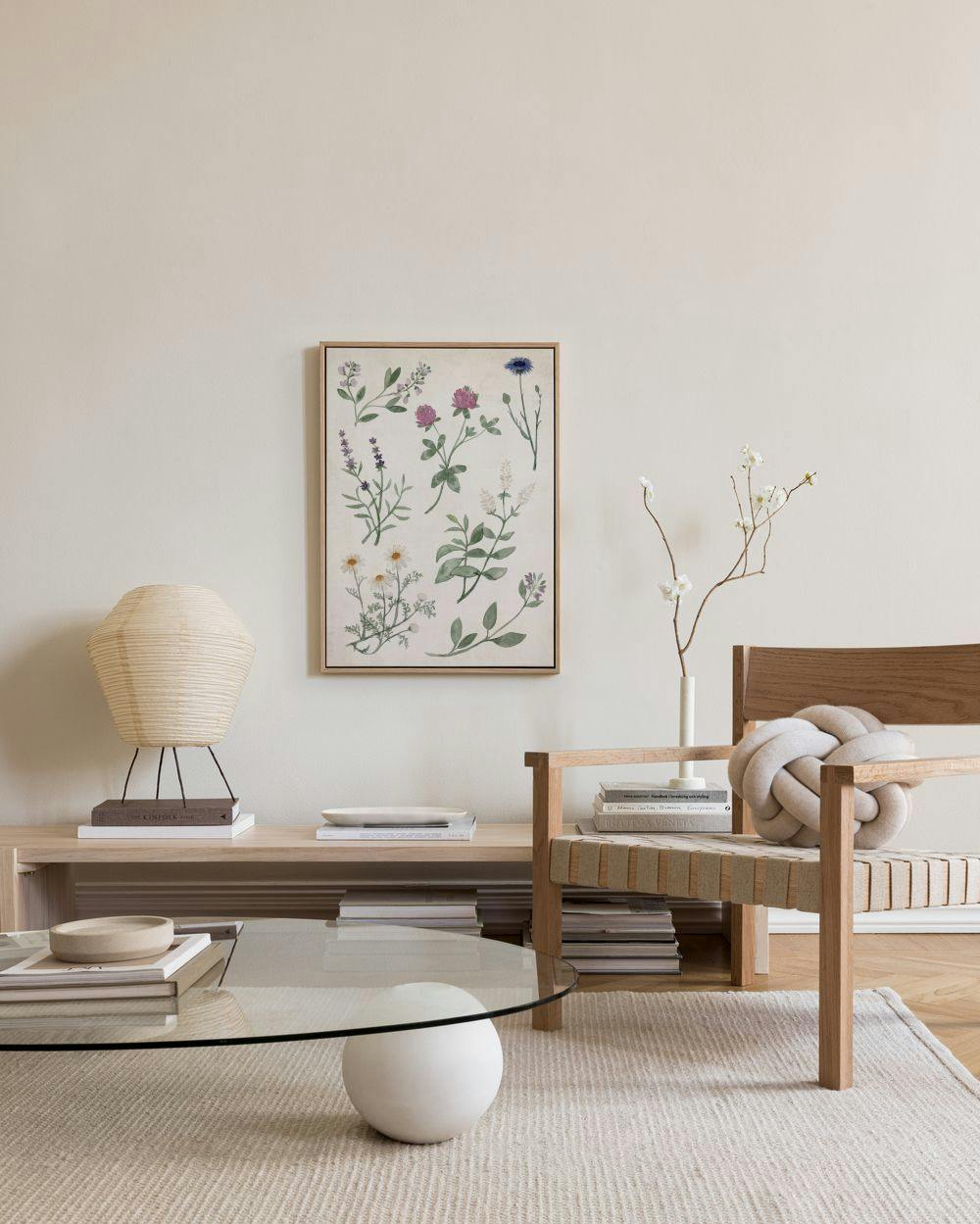 Leinwandbild mit botanischen Skizzen verschiedener Pflanzen wie Lavendel und Klee, über einem Holztisch in einem Wohnzimmer.