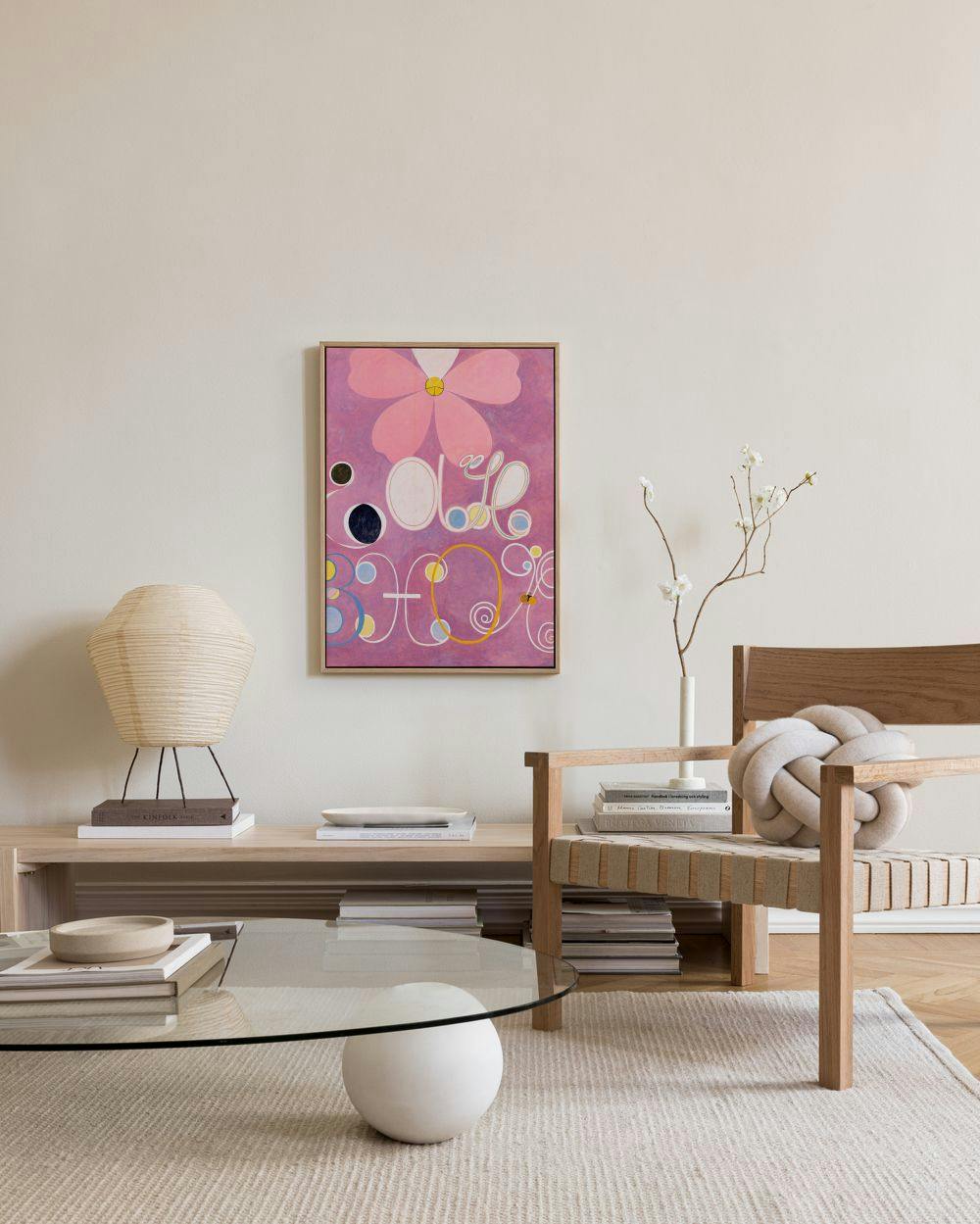 A canvas print with a large pink flower, black and white circles, and various other colourful shapes on a purple background, dis