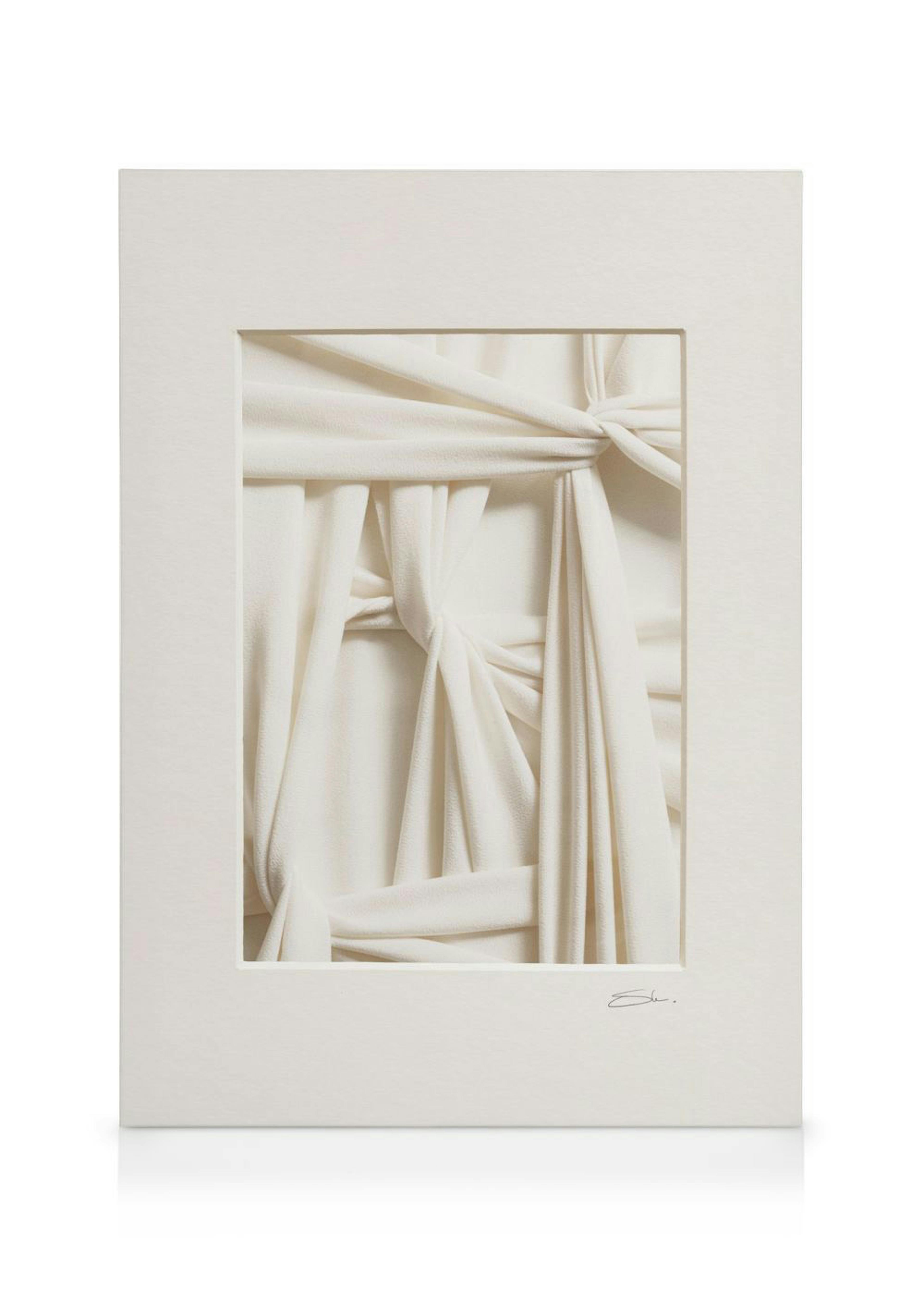 Canvas met minimalistische foto van gedrapeerde stof in witte en beige tinten, met knopen en plooien.