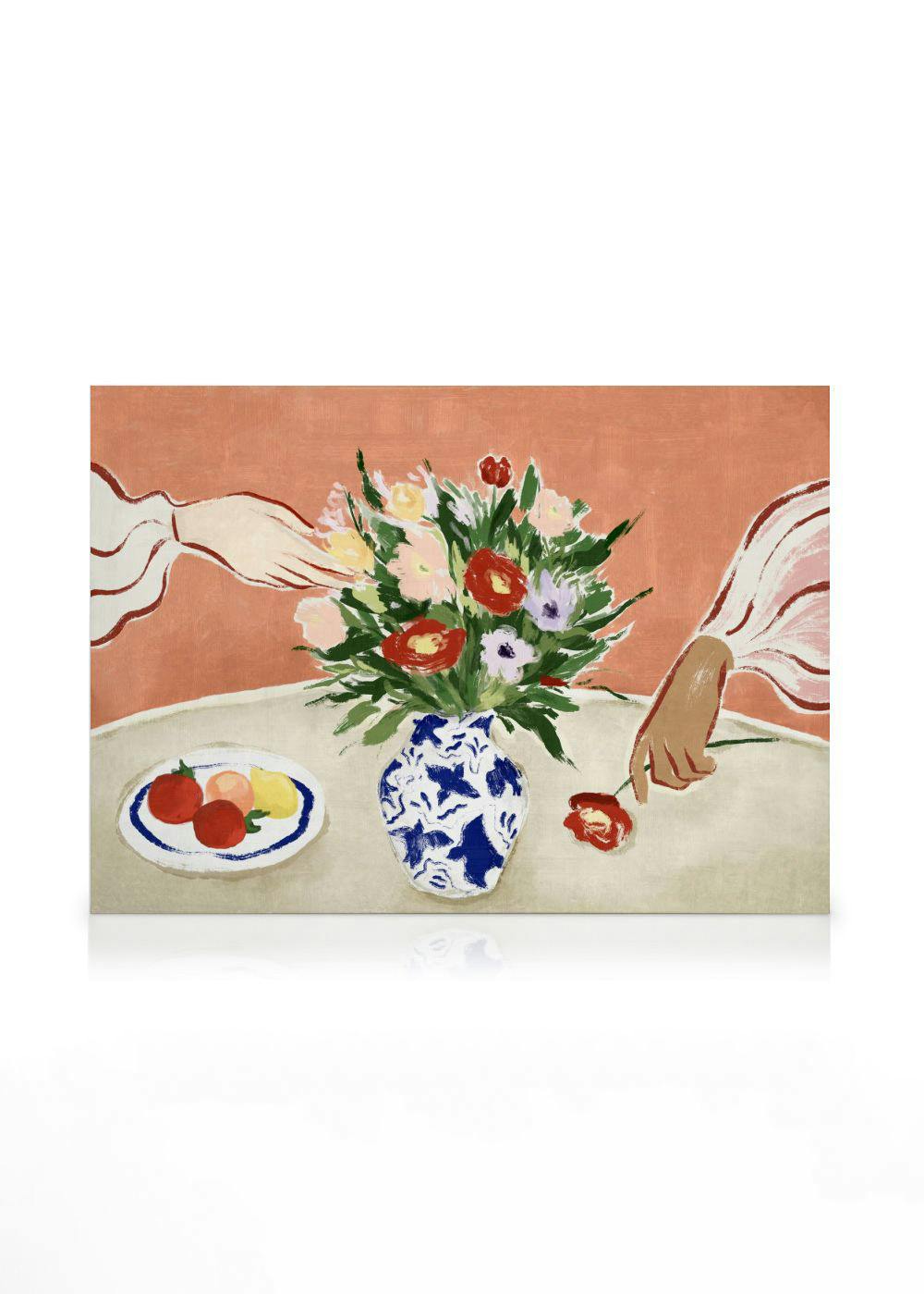 Colourful floral canvas print with a bouquet in a blue vase, fruit, and two hands on a table.