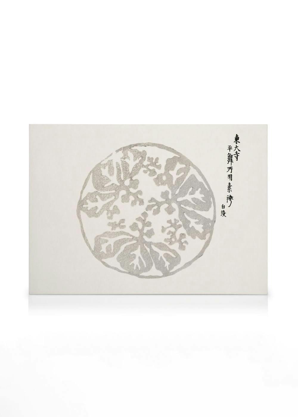 Japonský obraz s kruhovým motivem šedých listů jinanu dvoulaločného, s černými japonskými znaky po straně.