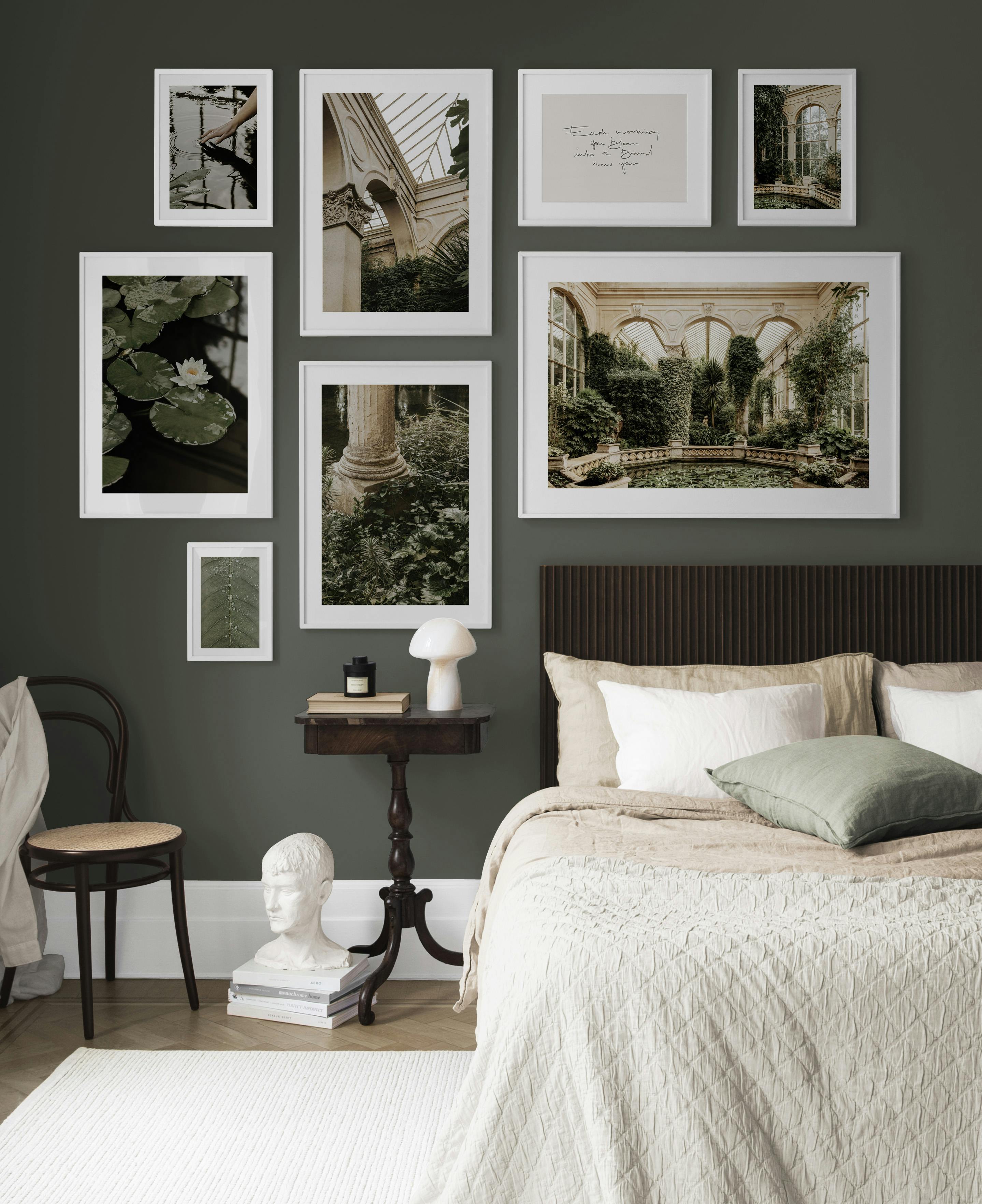 A gallery wall with botanical and architectural prints in a bedroom, featuring images of a greenhouse, water lilies, and a hand