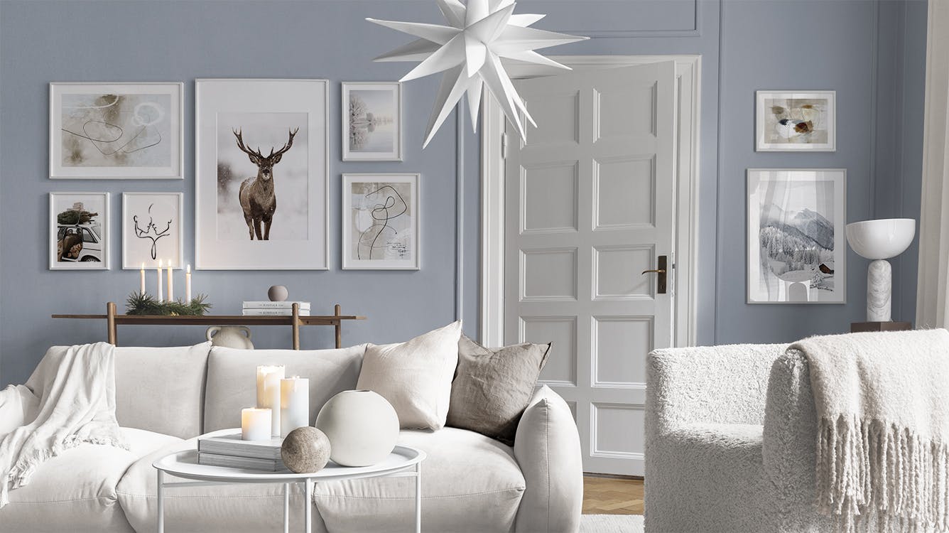 Décoration murale avec des affiches de formes abstraites, un cerf, un paysage enneigé et un sapin sur une voiture.