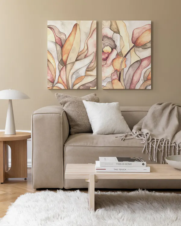 Two botanical shape canvases, one with yellow and orange shapes, the other with pink and beige, creating a soothing atmosphere.