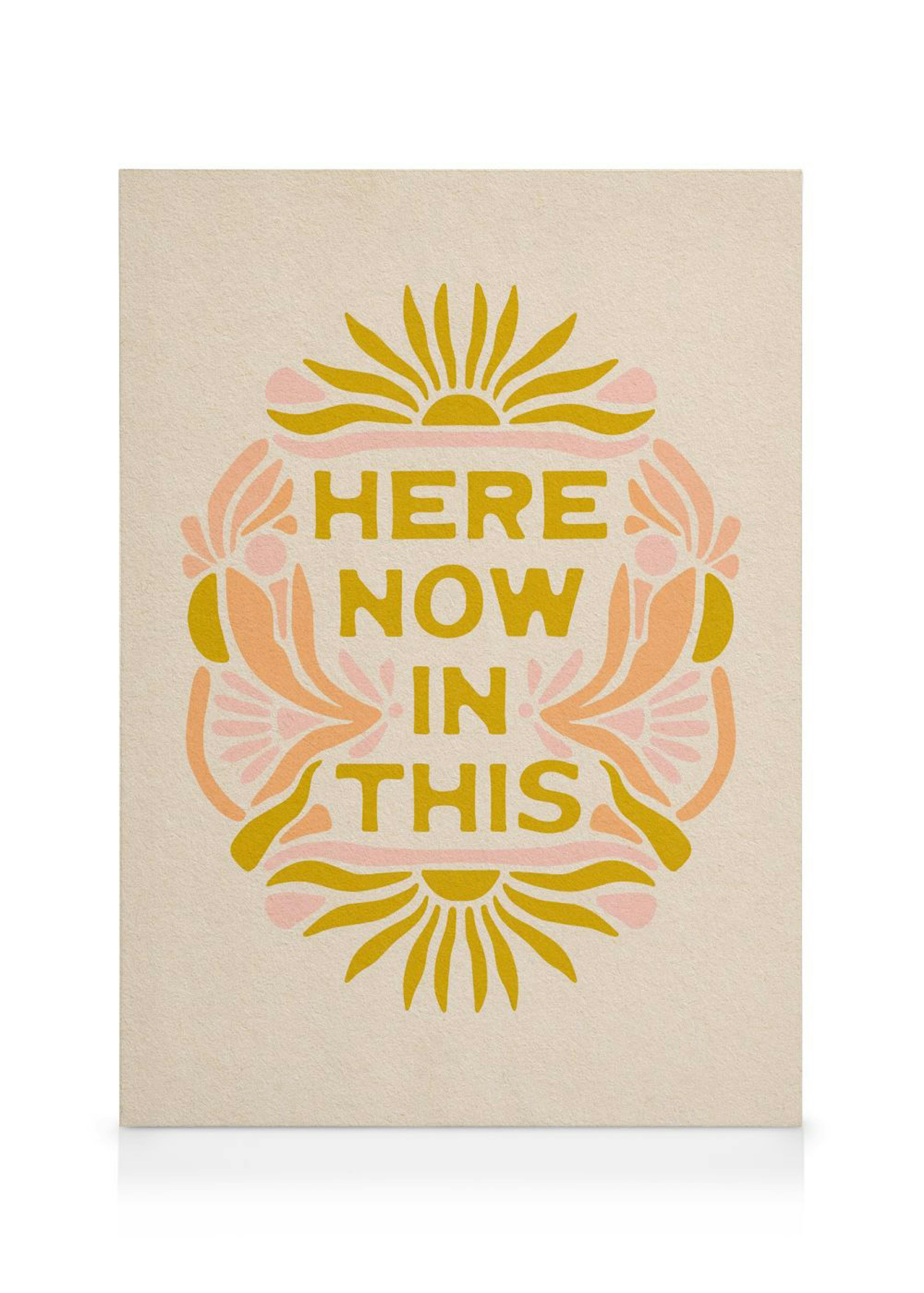 Obraz HERE NOW IN THIS se žlutým písmem, obklopený abstraktními květy a slunci v teplých barvách.