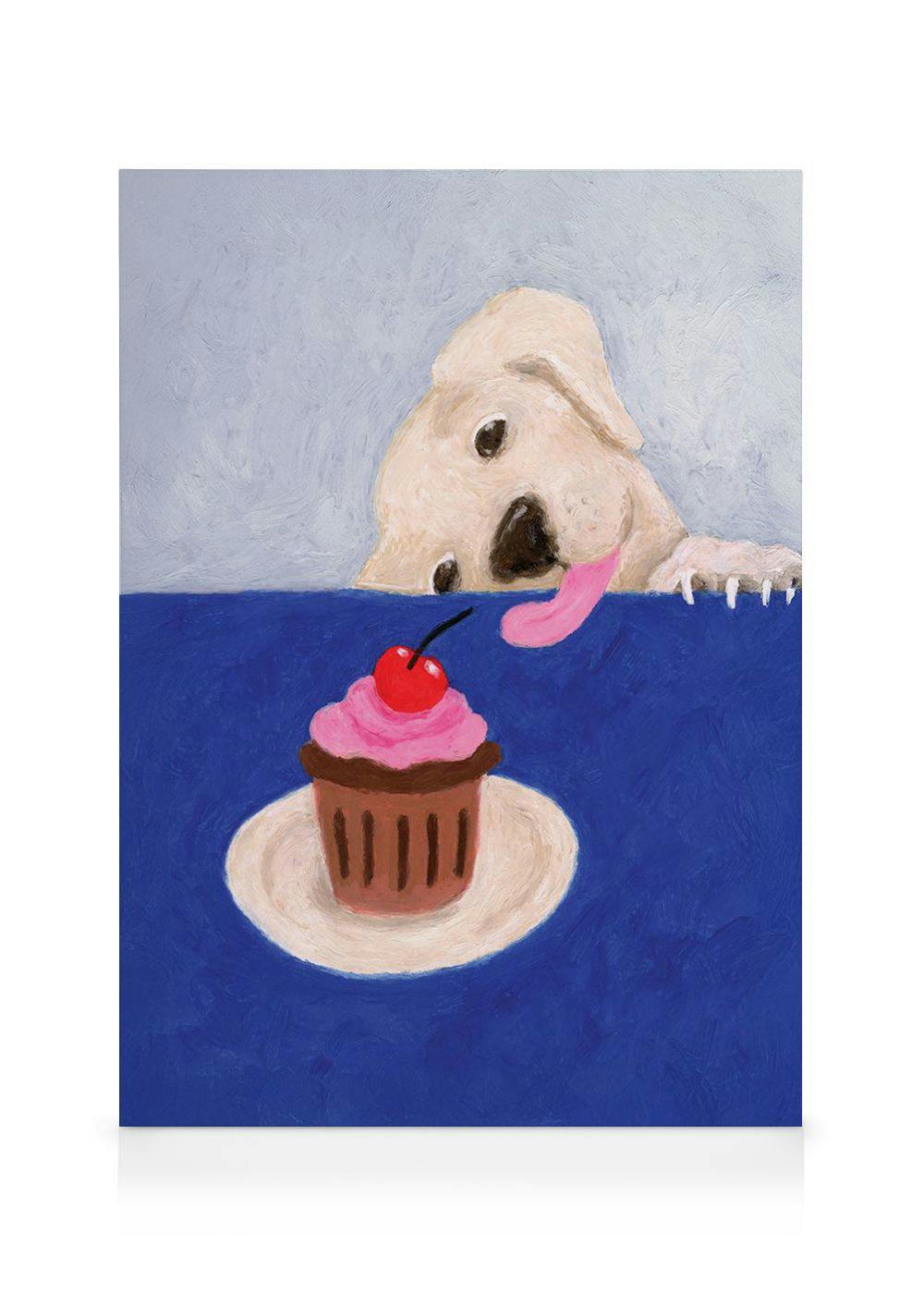 Toile représentant un chien beige léchant ses babines devant un cupcake rose et une cerise sur une table bleue.