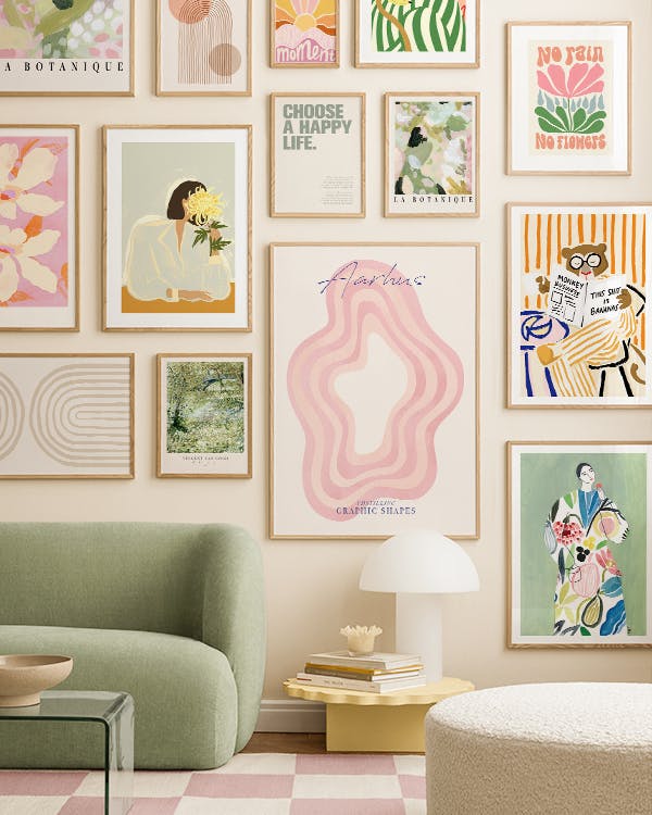 Een kleurrijke galeriewand met diverse kunstprints, waaronder bloemen, abstracte vormen en illustraties.