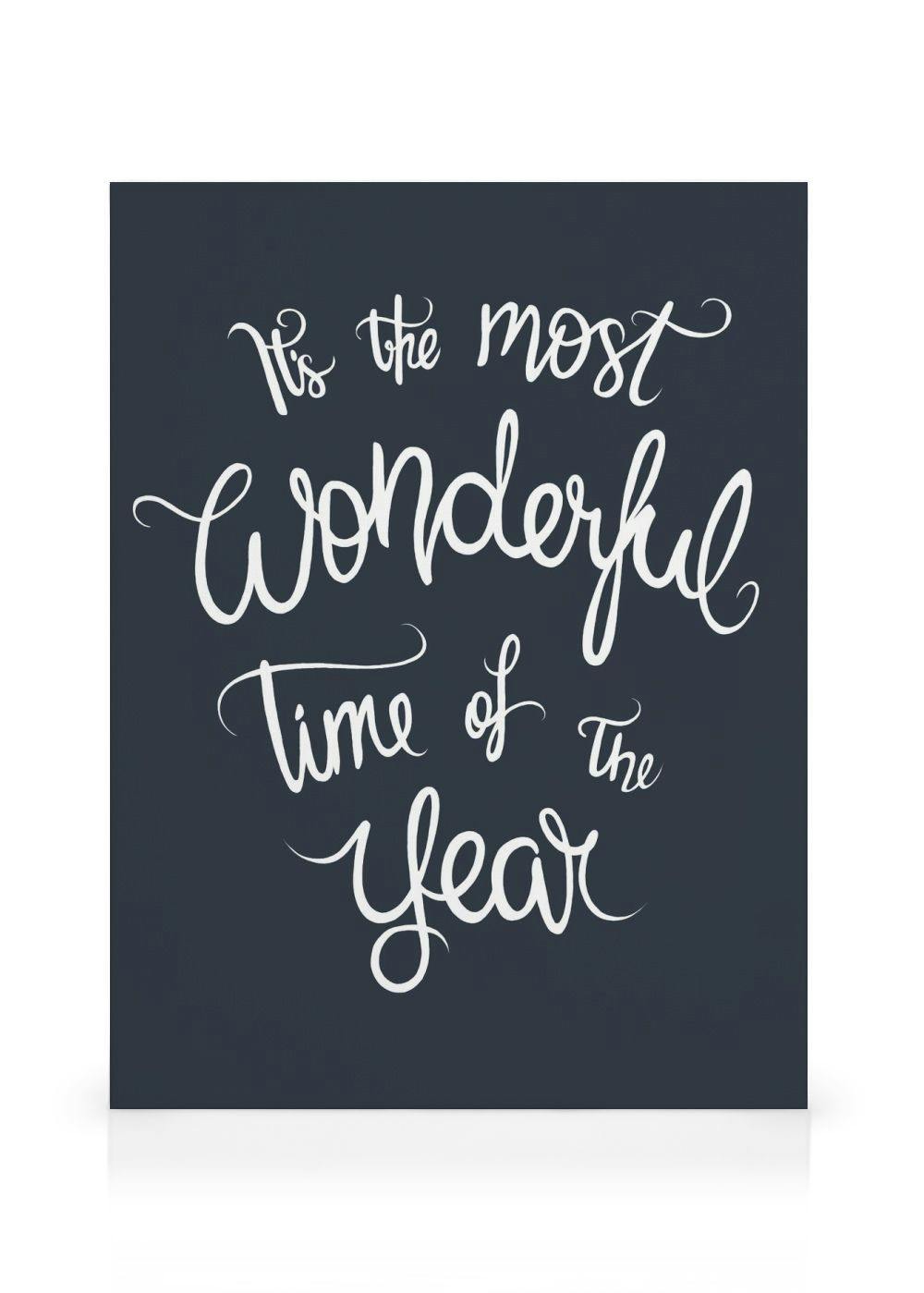 Canvas print with Its The Most Wonderful Time Of The Year in white cursive lettering on a dark blue background.