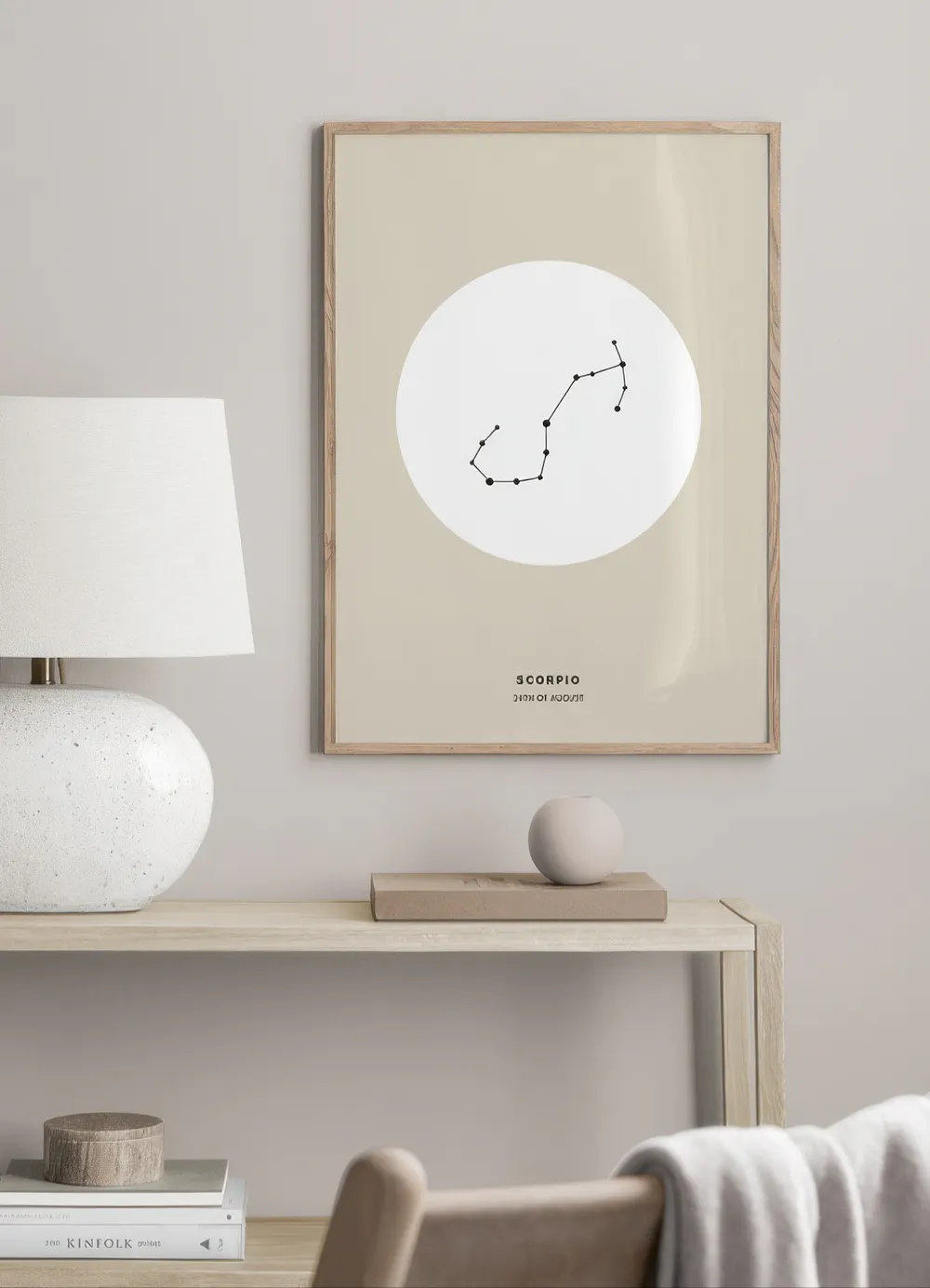 A personalized Scorpio constellation print displayed above a light wood console table with a lamp and books.