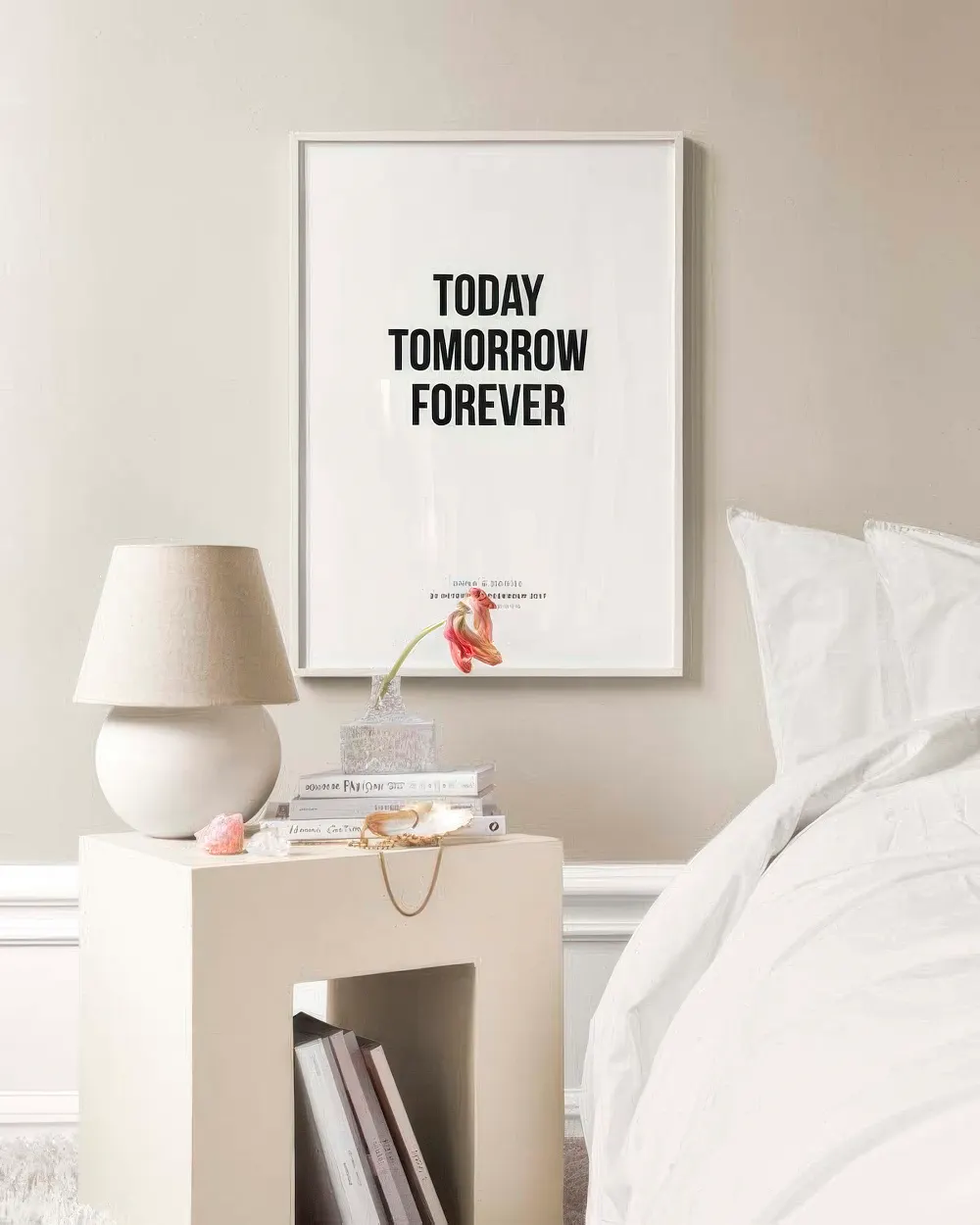 A personalized print with the text “TODAY TOMORROW FOREVER” in black, displayed above a bedside table in a bedroom.