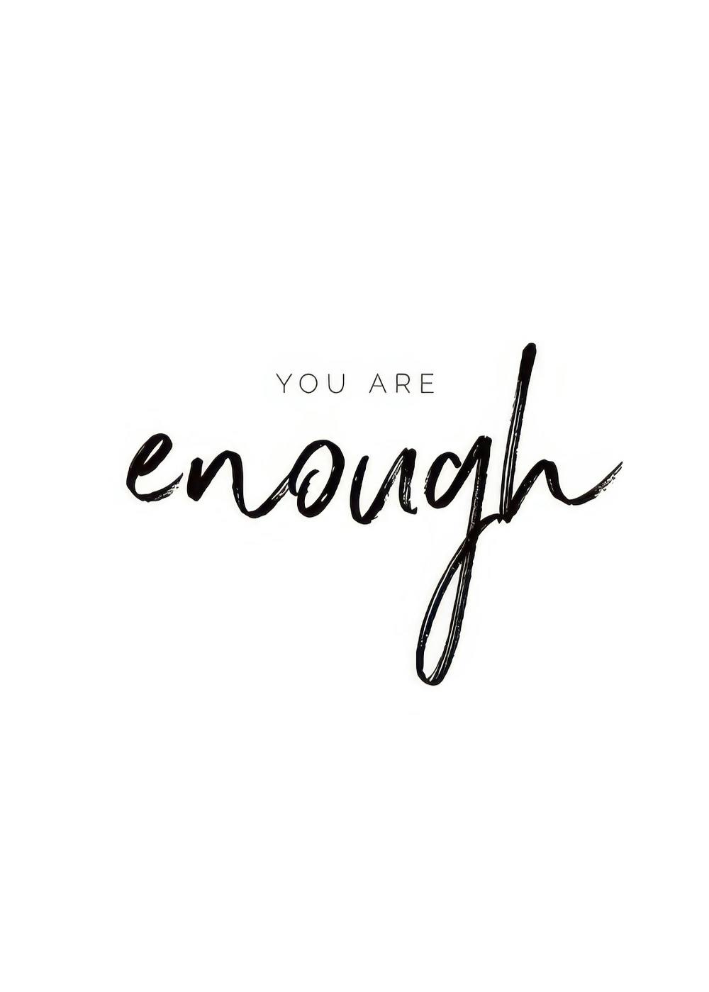 Plakat z czarnym tekstem YOU ARE enough na białym tle. Słowa YOU ARE są mniejszą, prostą czcionką, a enough większą, pędzlowaną
