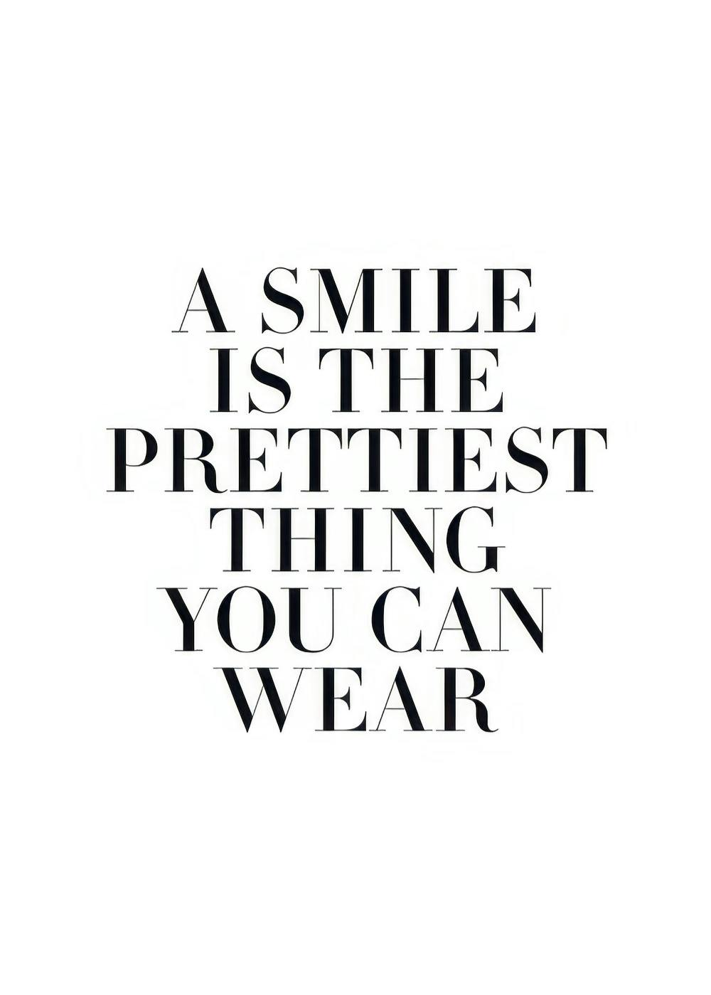 Affiche avec la citation A smile is the prettiest thing you can wear en typographie noire sur fond blanc.