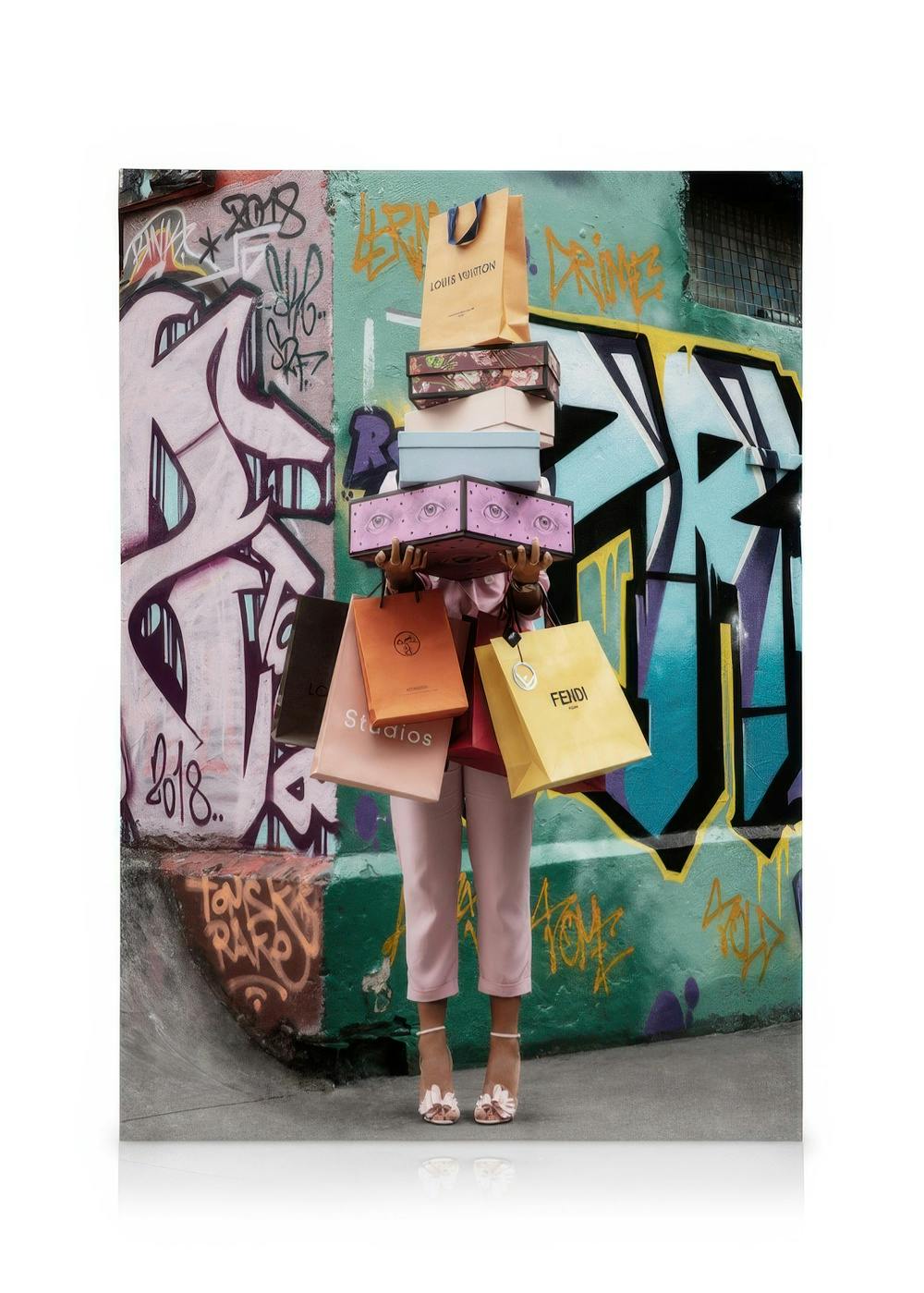 Toile montrant une personne tenant des boîtes et sacs de créateurs, sur fond de mur graffiti violet, noir et sarcelle.