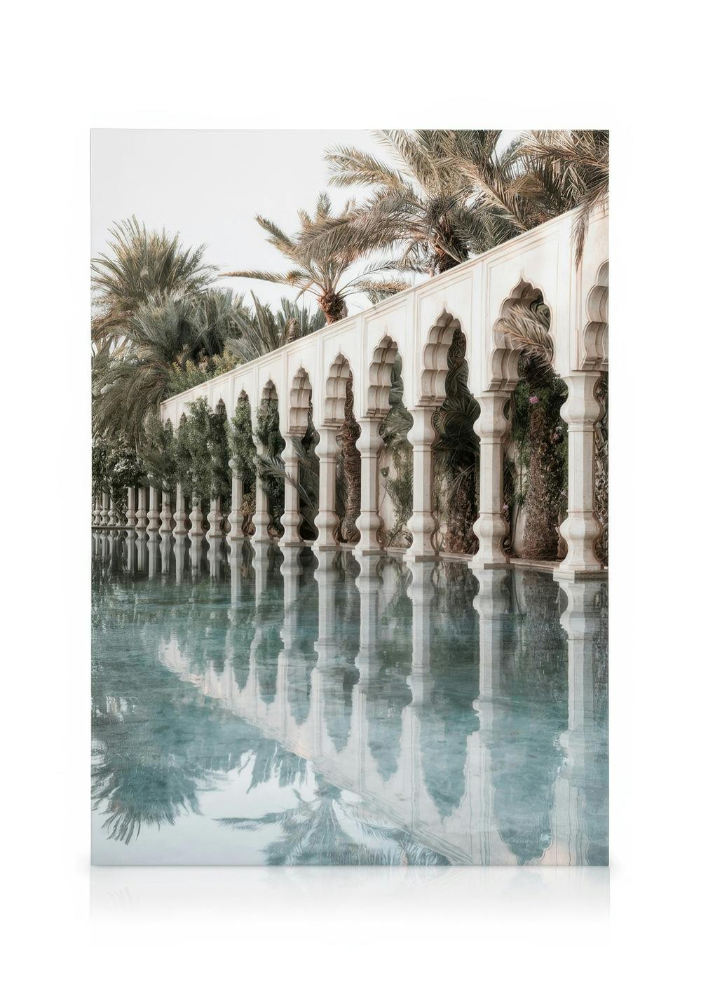 Leinwandbild mit weißer Arkade, Palmen und klarem blauen Wasser, das sich darin spiegelt, Secret Garden Motiv.