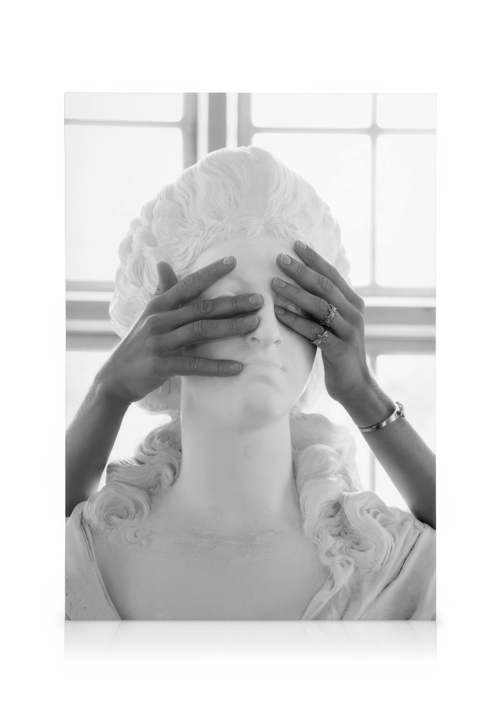 Toile en noir et blanc dune statue avec des mains couvrant ses yeux, un motif artistique avec une typographie élégante.