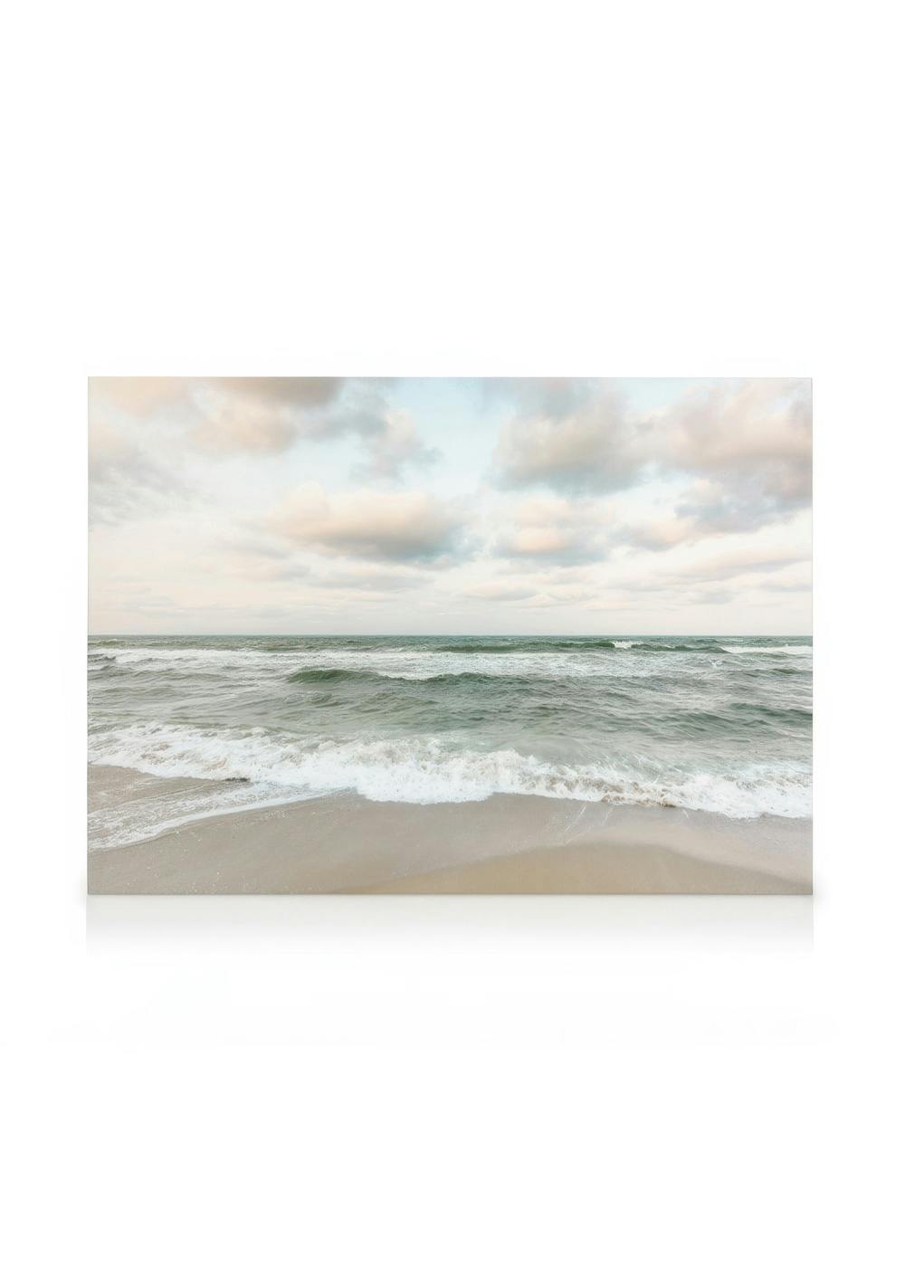 Stampa su tela di onde verde giada che si infrangono su una spiaggia sabbiosa, cielo nuvoloso beige pallido sullo sfondo.