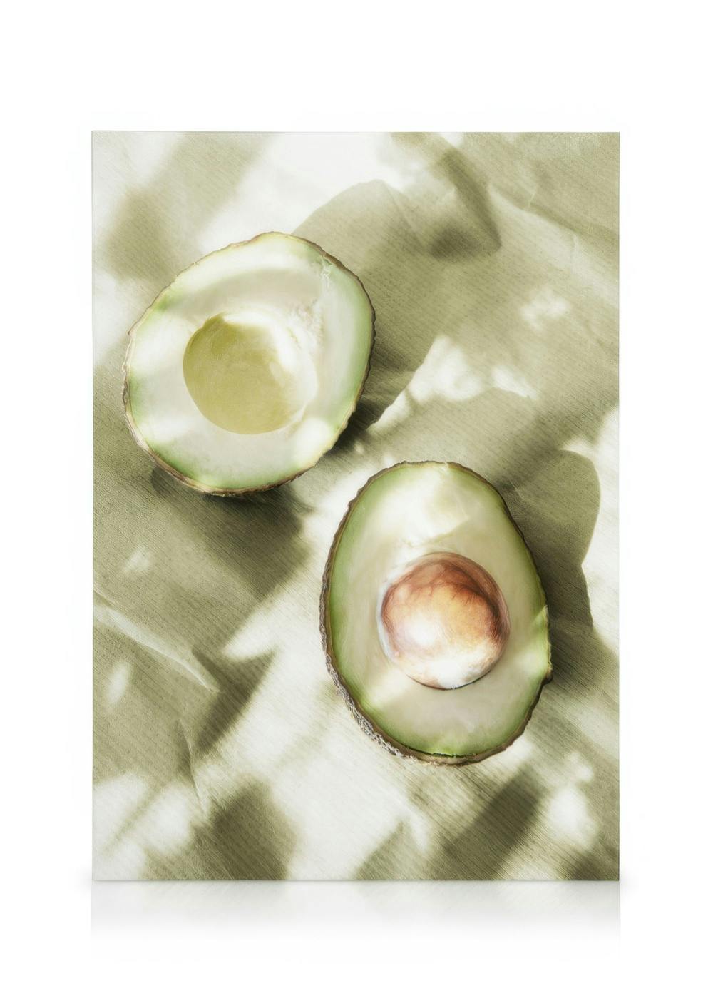 Toile de deux moitiés davocat sur fond beige clair, une moitié avec noyau, sous la lumière du soleil