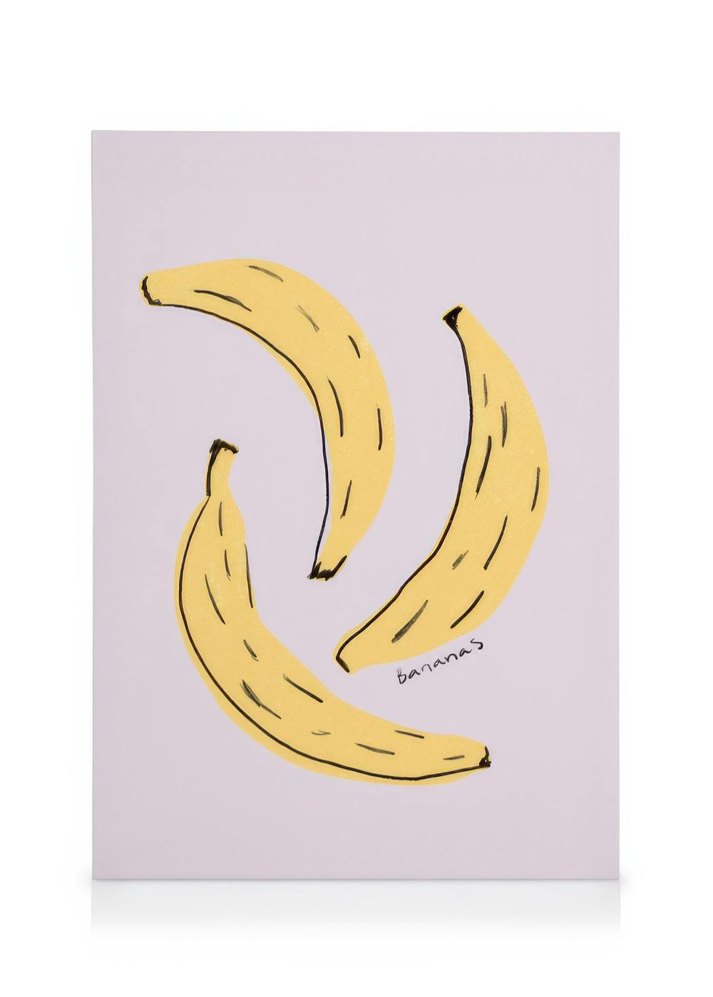 Obraz na płótnie z trzema żółtymi bananami na jasnoróżowym tle, idealny do kuchni.