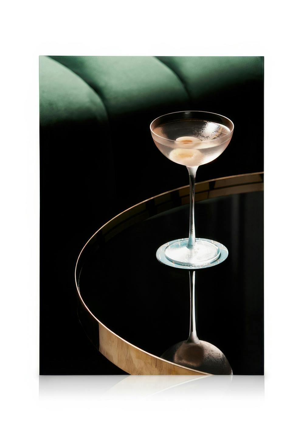 Canvastavla med cocktailglas på spegelbord, grön kudde och svart bakgrund. Elegant drinkmotiv.