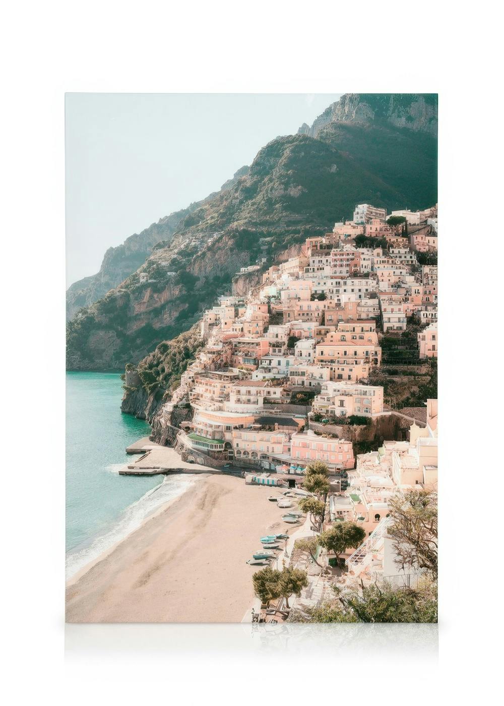 Toile de Positano, ville côtière avec maisons colorées sur une colline, plage de sable et océan bleu en arrière-plan.