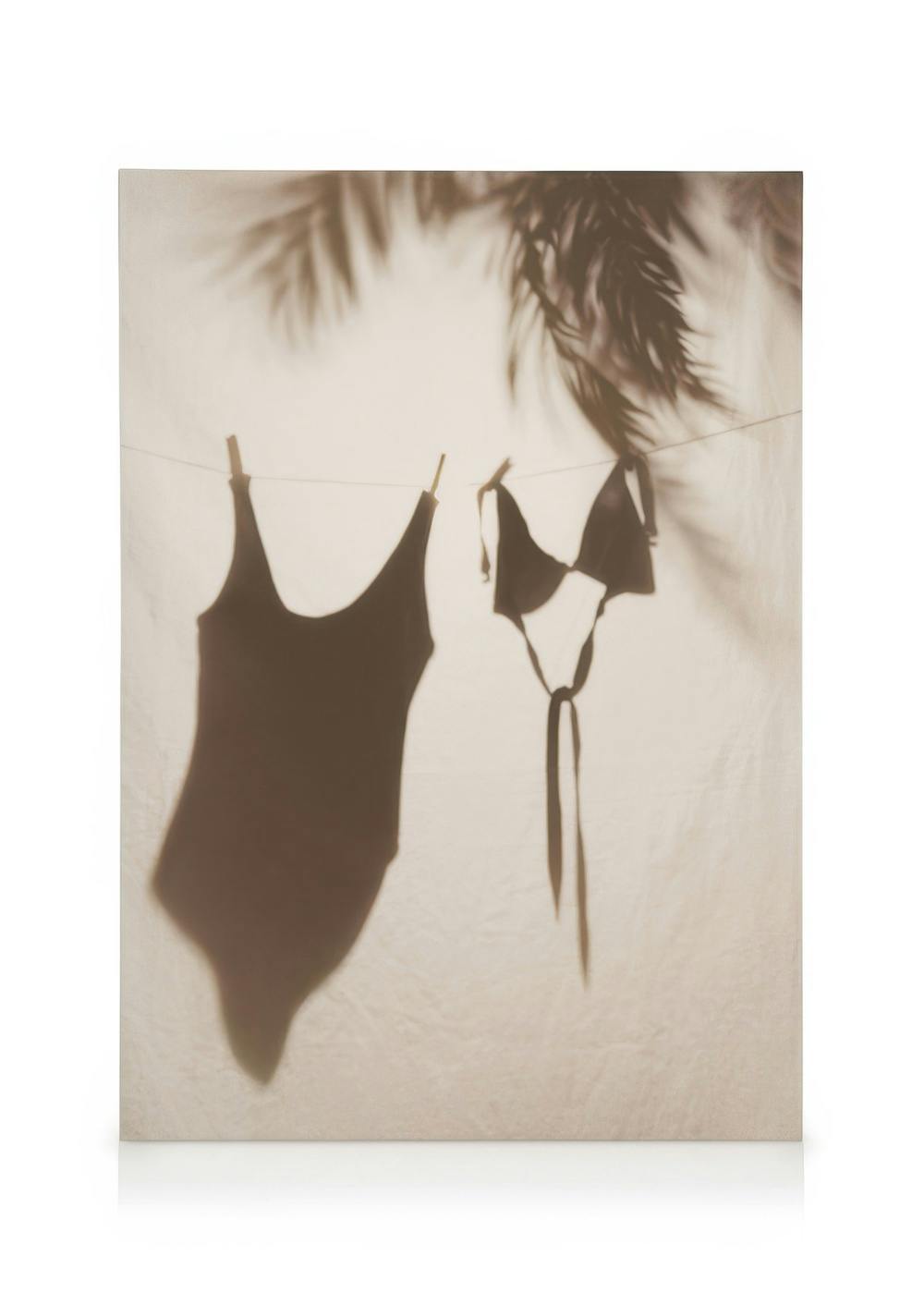 Canvas met schaduwen van badpakken en palmbladeren, tropische sfeer op off-white achtergrond.