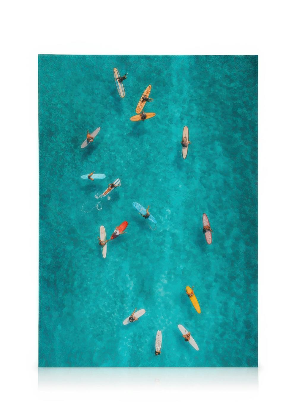 Aerial view of surfers on colourful surfboards floating on clear blue ocean water, a serene surfing art print.