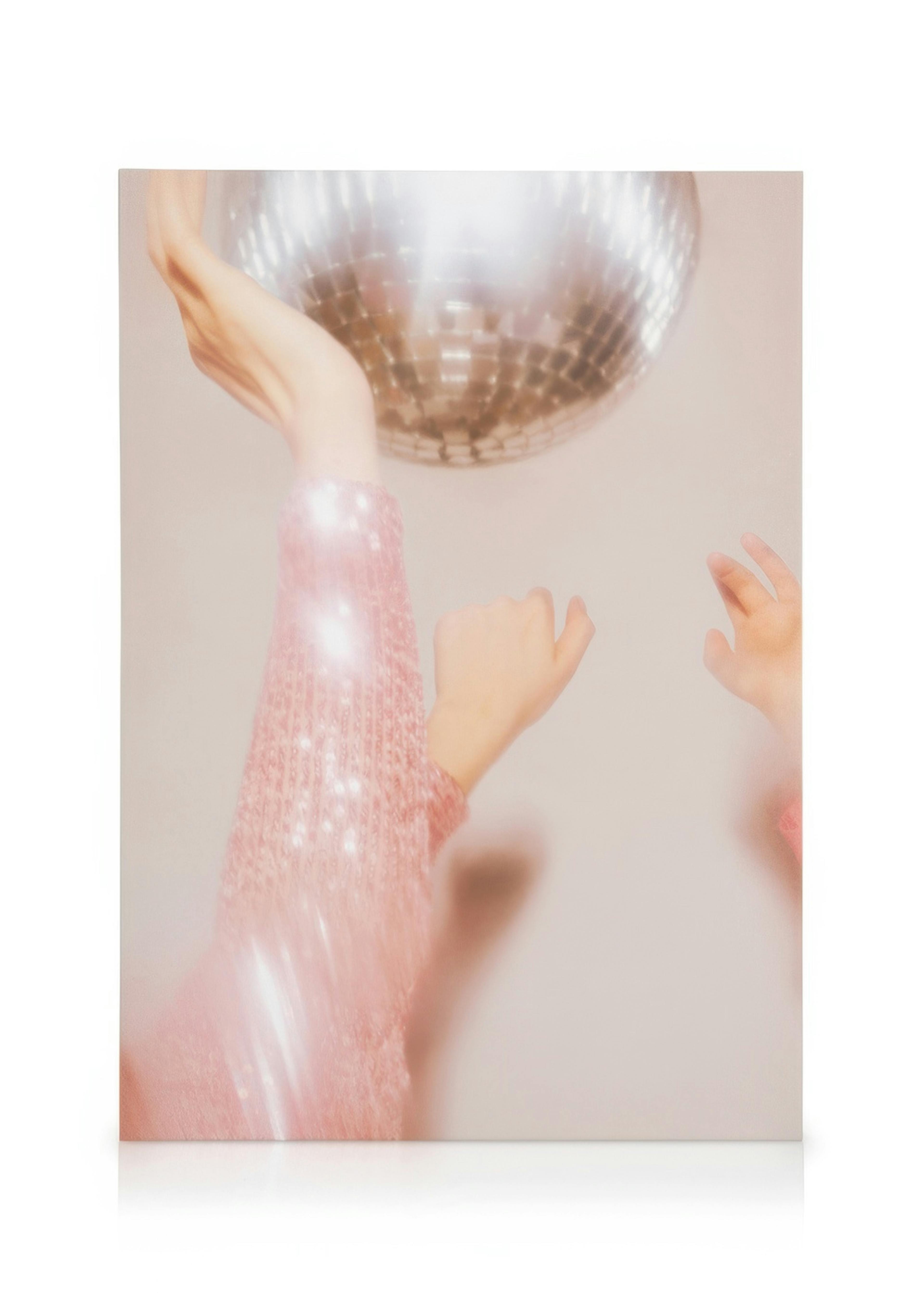 Sparkly pink sleeves reaching for a spinning disco ball canvas print with motion blur.