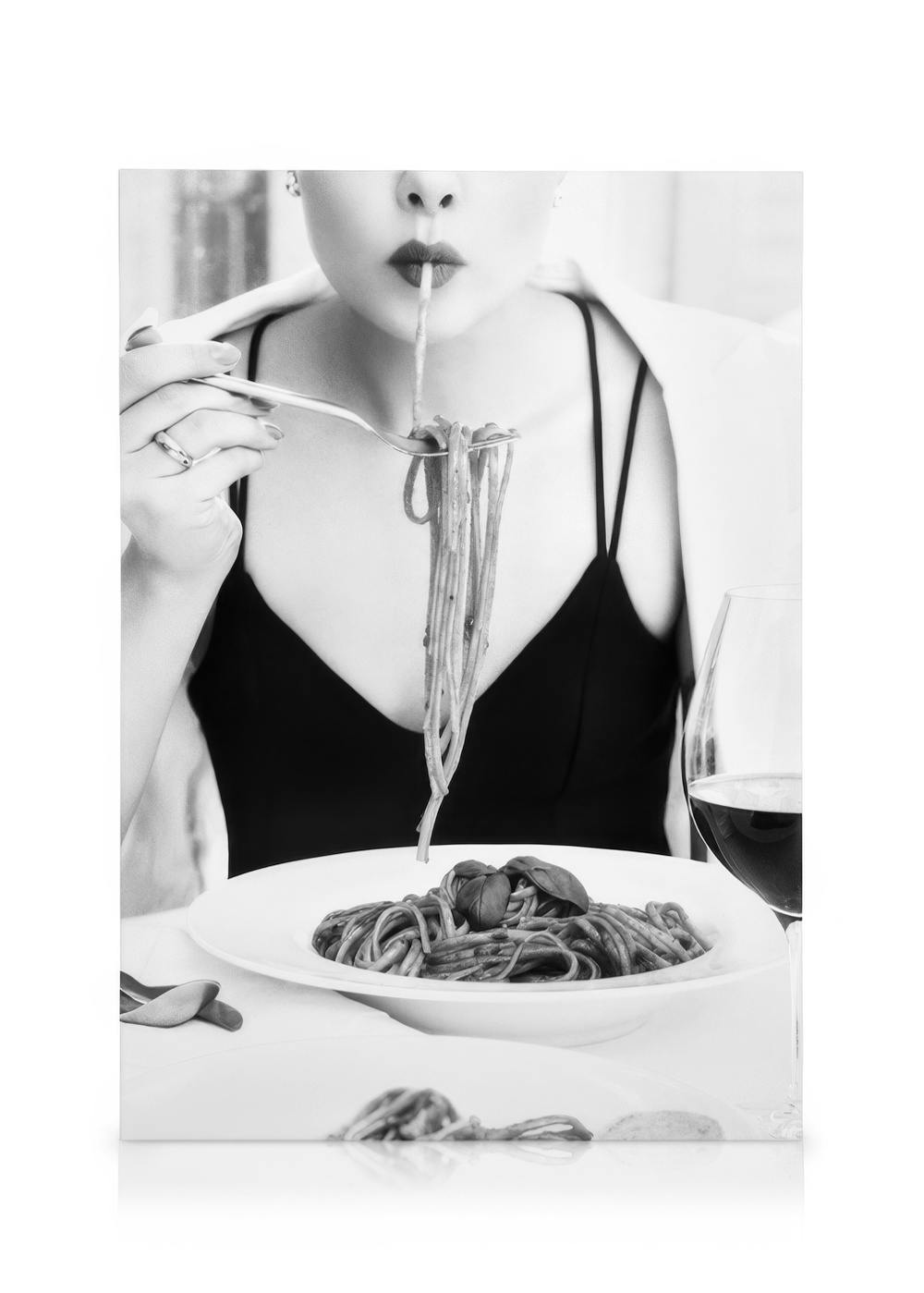 Schwarz-Weiß-Leinwandbild einer Frau, die elegant Spaghetti isst, mit rotem Lippenstift und Weinglas. Italienisches Essen Kunst.