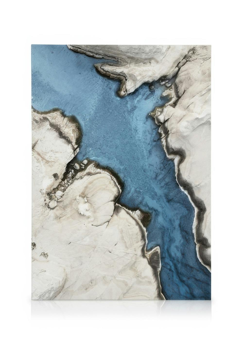Abstrakte Vogelperspektive des türkisfarbenen Flusses durch eine felsige, grau-weiße Wüstenlandschaft, Leinwandbild.