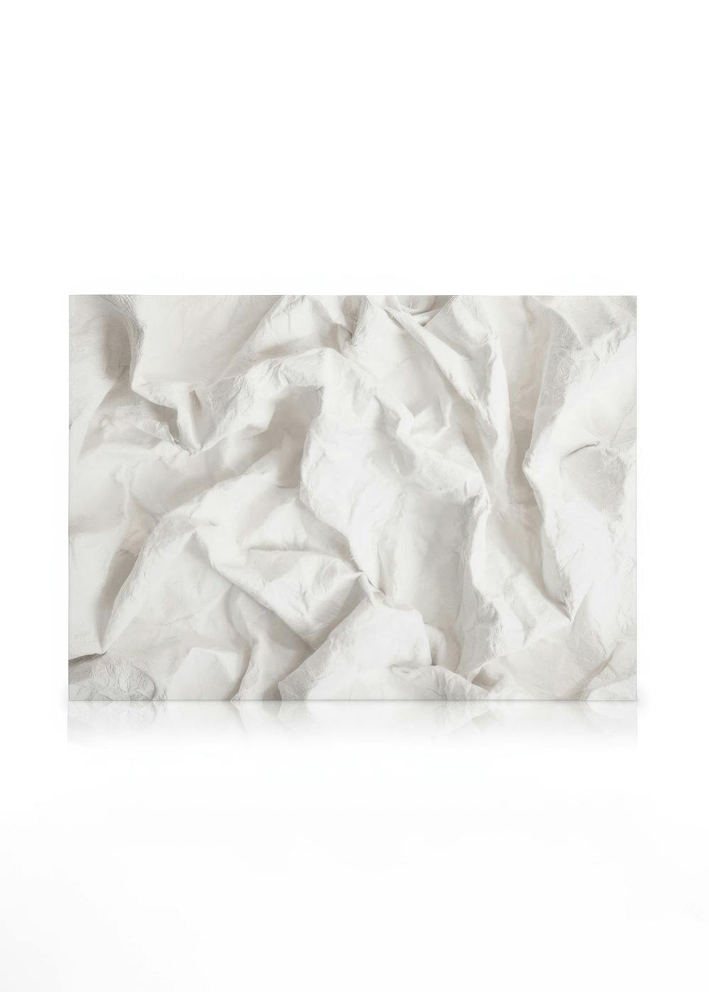 White crumpled paper texture on a canvas print, featuring distinct folds and creases on a light background.