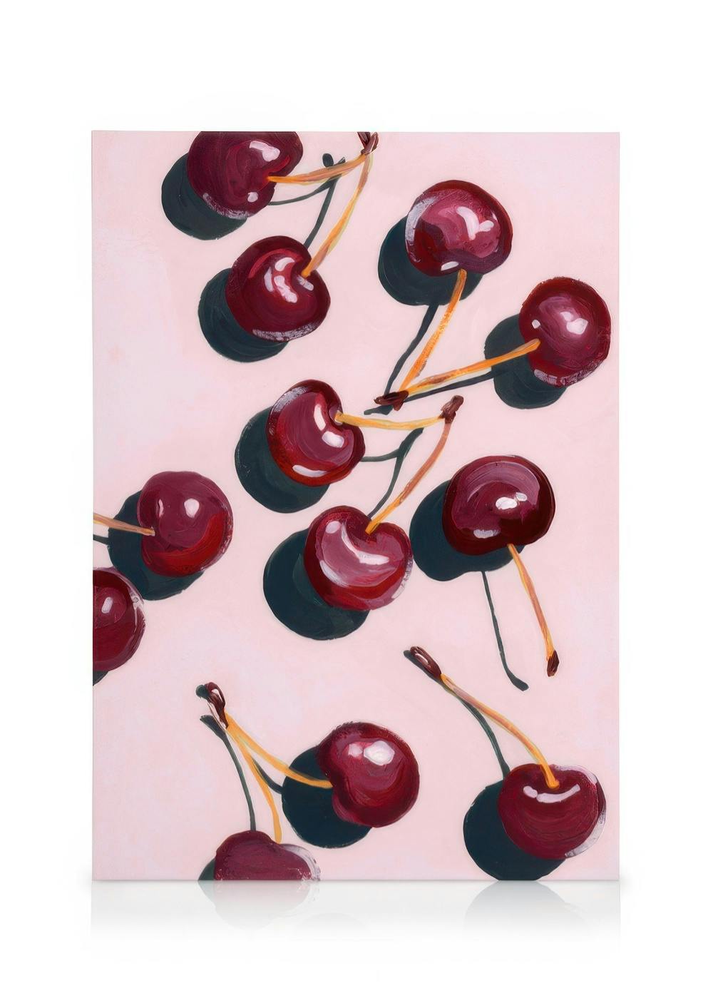 Stampa su tela con ciliegie rosse su sfondo rosa, alcune intere, altre morse, con gambi e riflessi chiari.