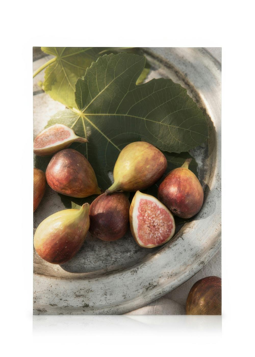 Higos maduros en plato rústico con hoja verde, tonos púrpura, rojo y blanco, fotografía naturaleza muerta.