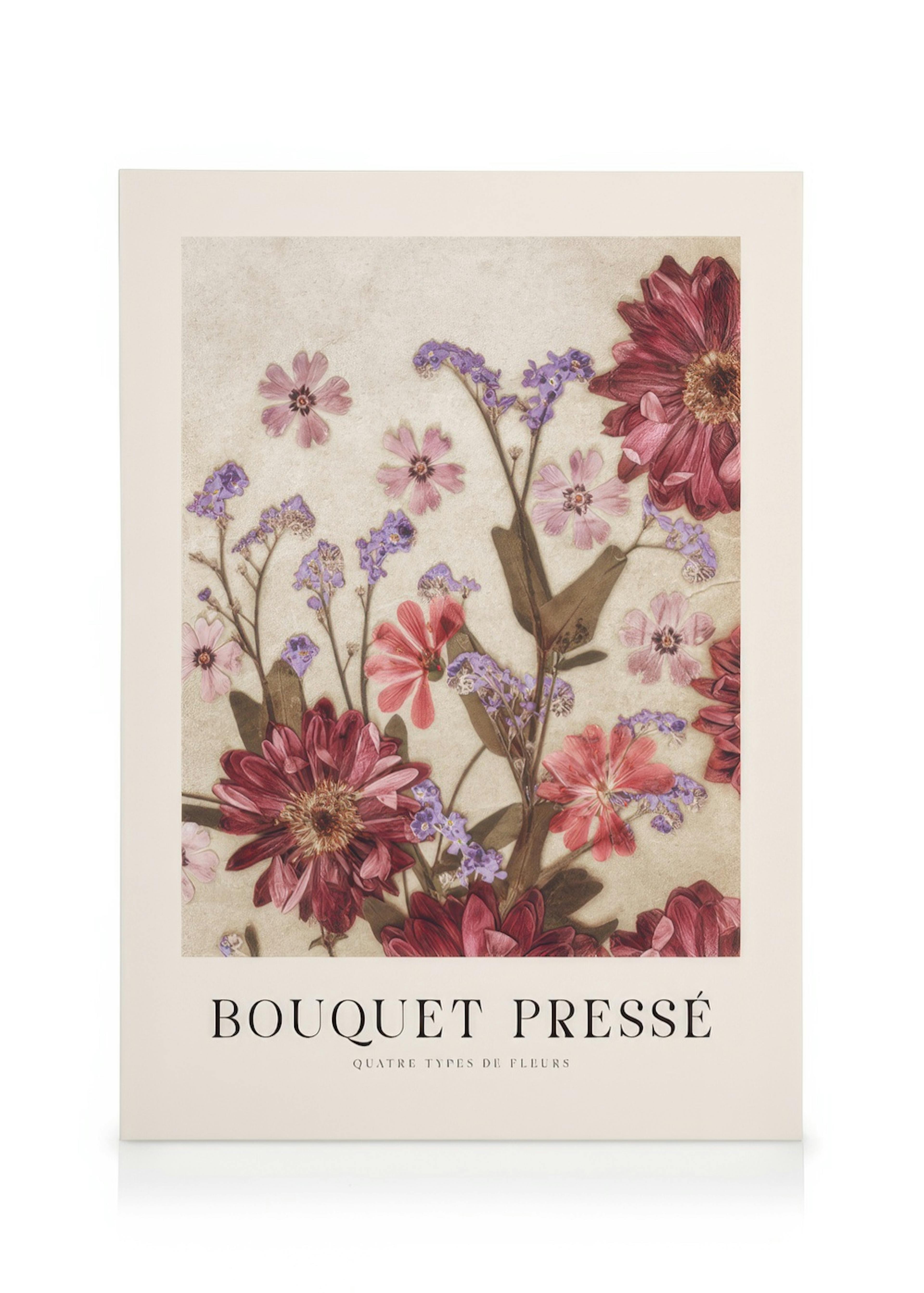 Een canvas met een print van een geperst boeket bloemen in rood, paars en roze, hangend in een lichte woonkamer.