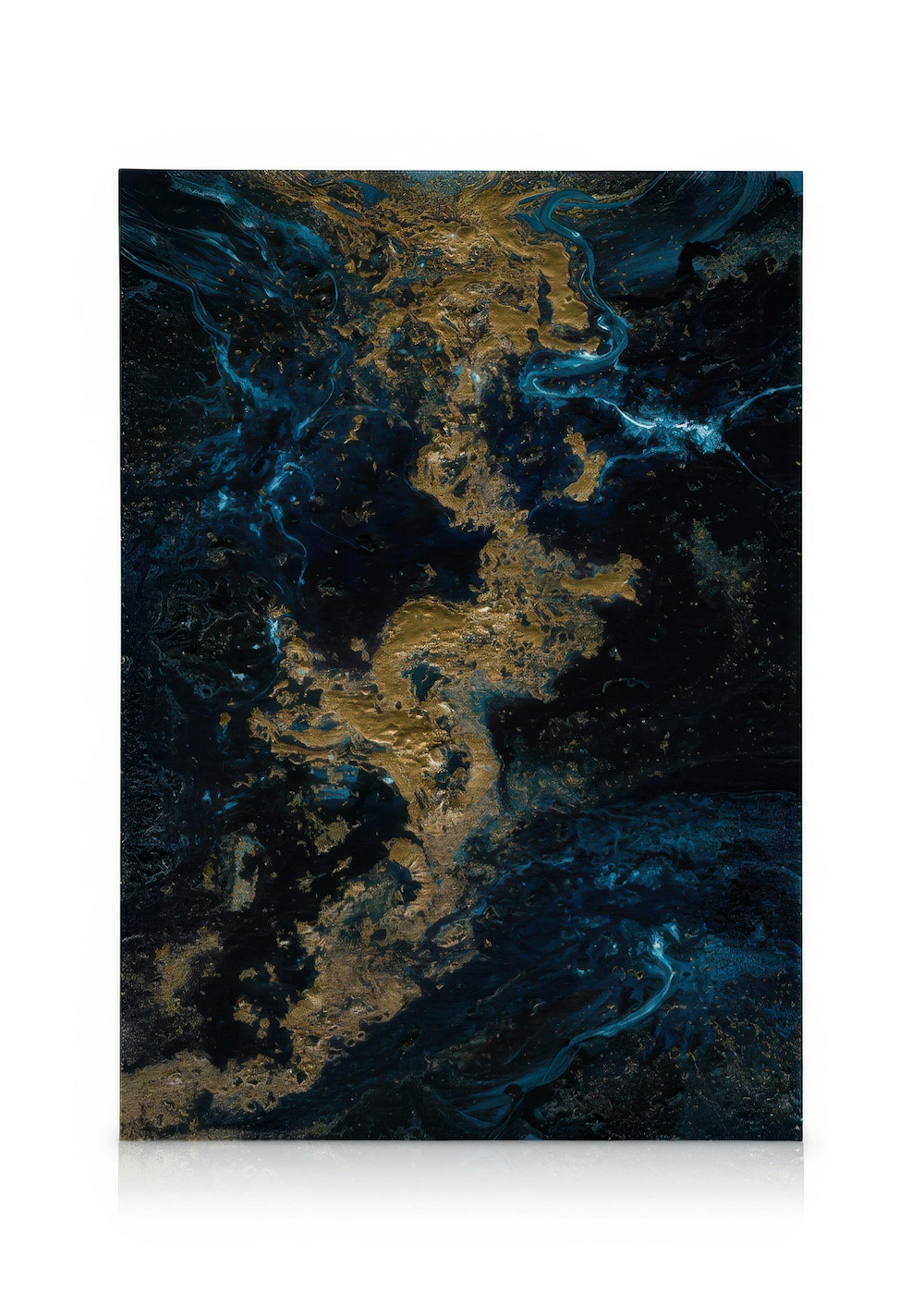An abstract canvas print with swirling gold and deep blue patterns, displayed on a light wall in a minimalist living room.