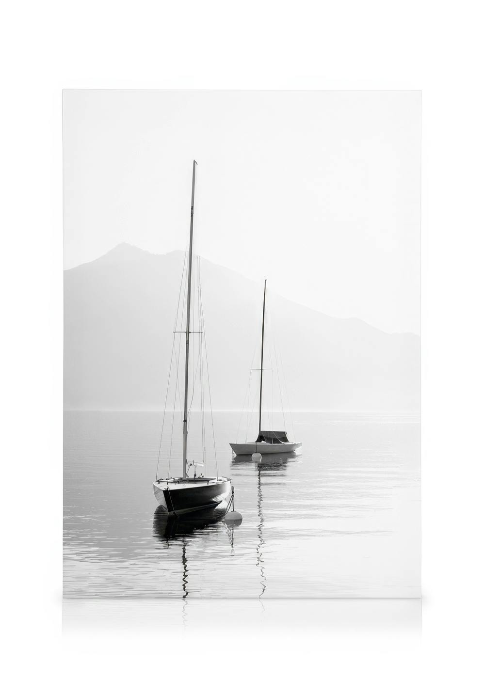 Schwarz-weiß-Leinwandbild mit zwei Segelbooten auf ruhigem Wasser, umgeben von Nebel und Bergen. Minimalistische Bootslandschaft