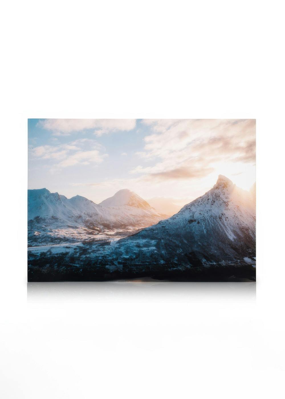 Snow-covered Alps mountains at sunrise, golden light on peaks, blue sky with clouds, alpine landscape art.