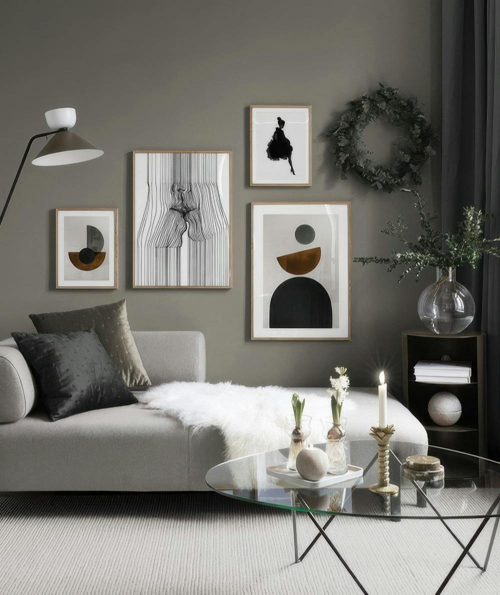 En tavelvägg med abstrakt konst i grått, svart, vitt och brunt. Motiv inkluderar ansikten, geometriska former och en siluett.