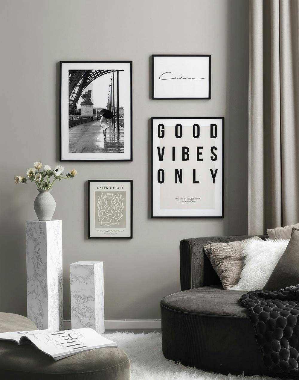 A gallery wall with a black and white print of a person with an umbrella on a rainy bridge, a Calm script print, a Good Vibes On