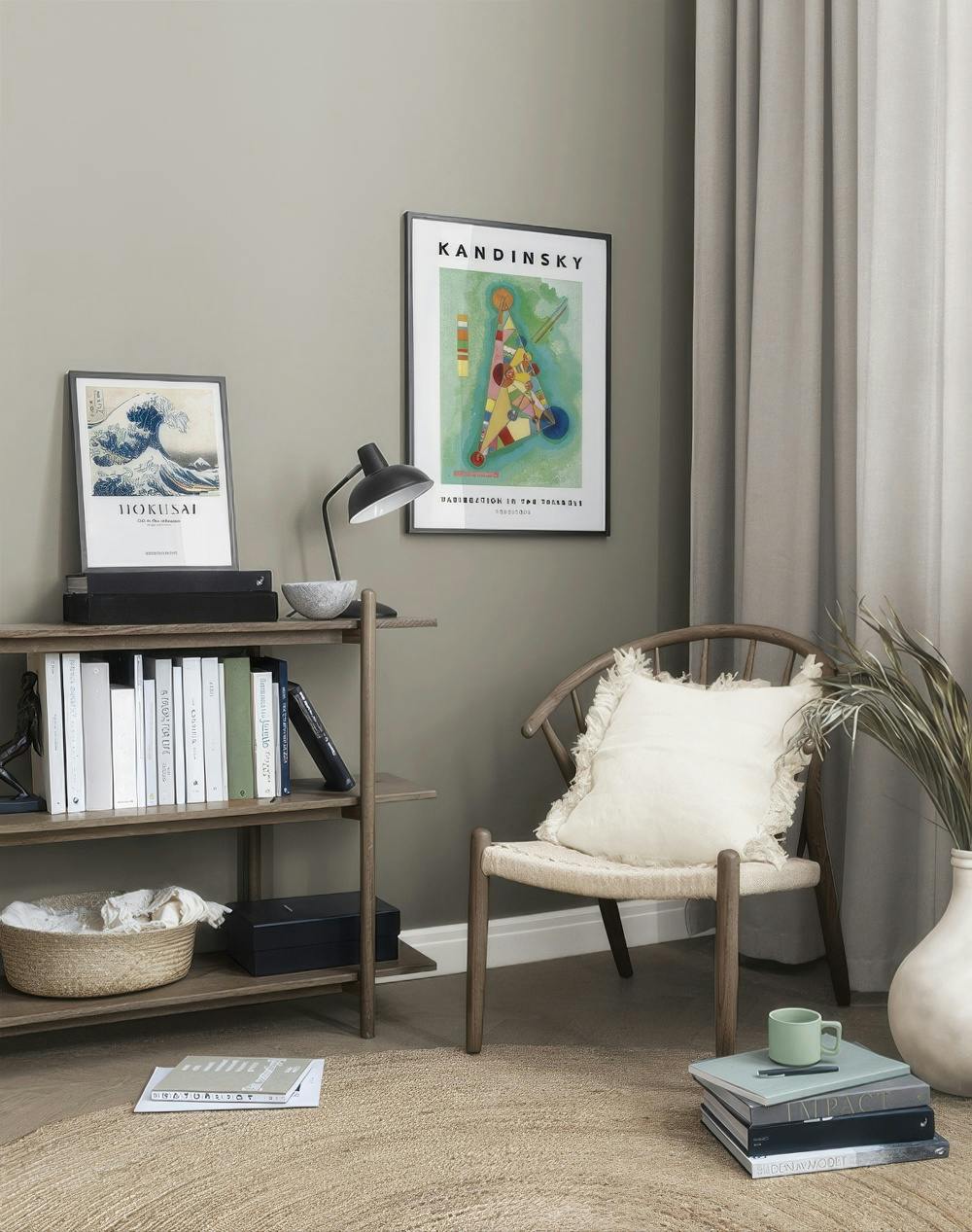 En tavelvägg med Kandinskys trianglar i starka färger och Hokusais ikoniska våg i ett mysigt vardagsrum.