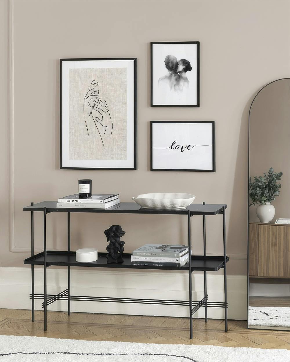 A gallery wall with three prints: line art hands, a couple in an embrace, and the word love.