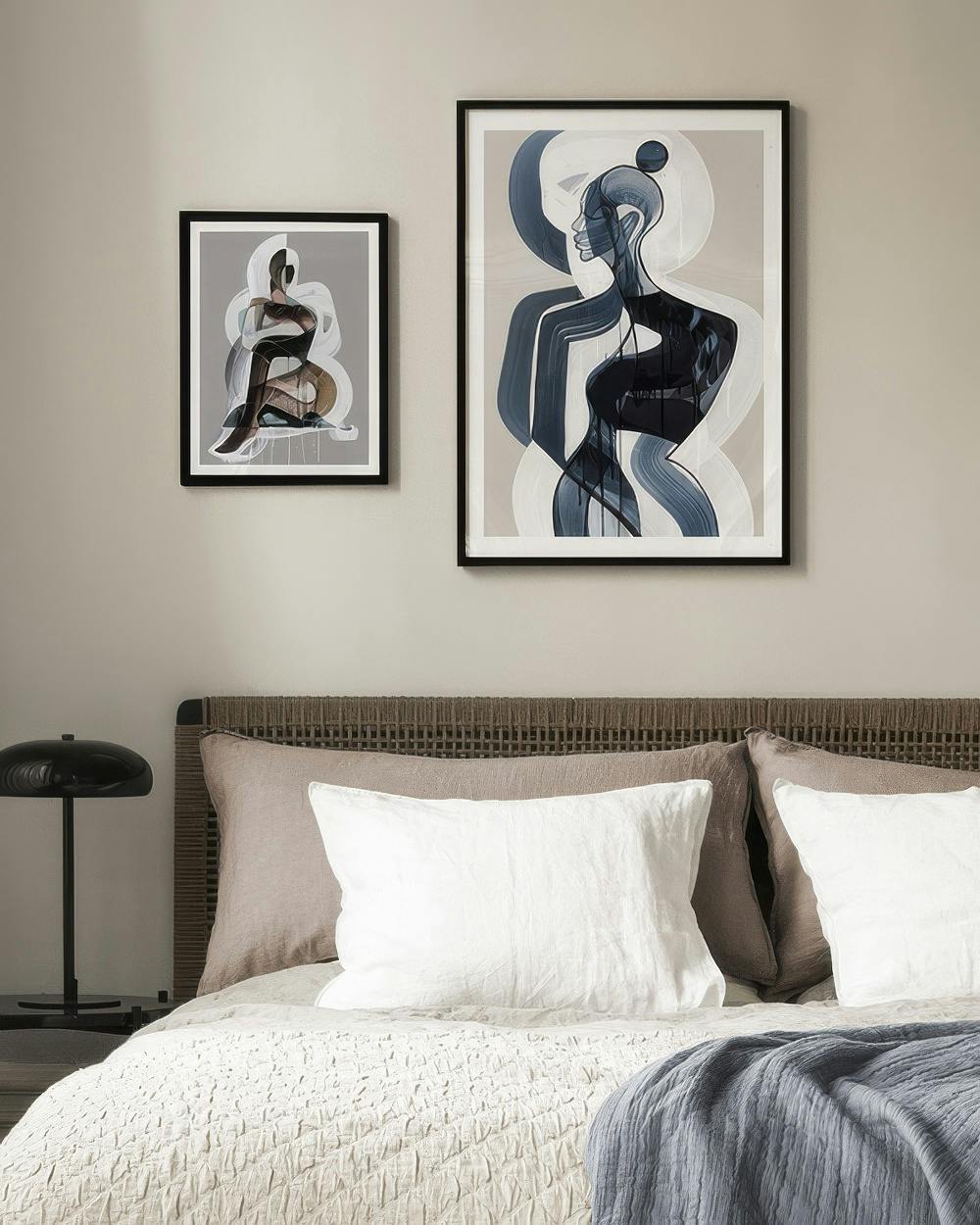 Décoration murale avec deux illustrations abstraites de silhouettes féminines en teintes de bleu, blanc et beige dans une chambr