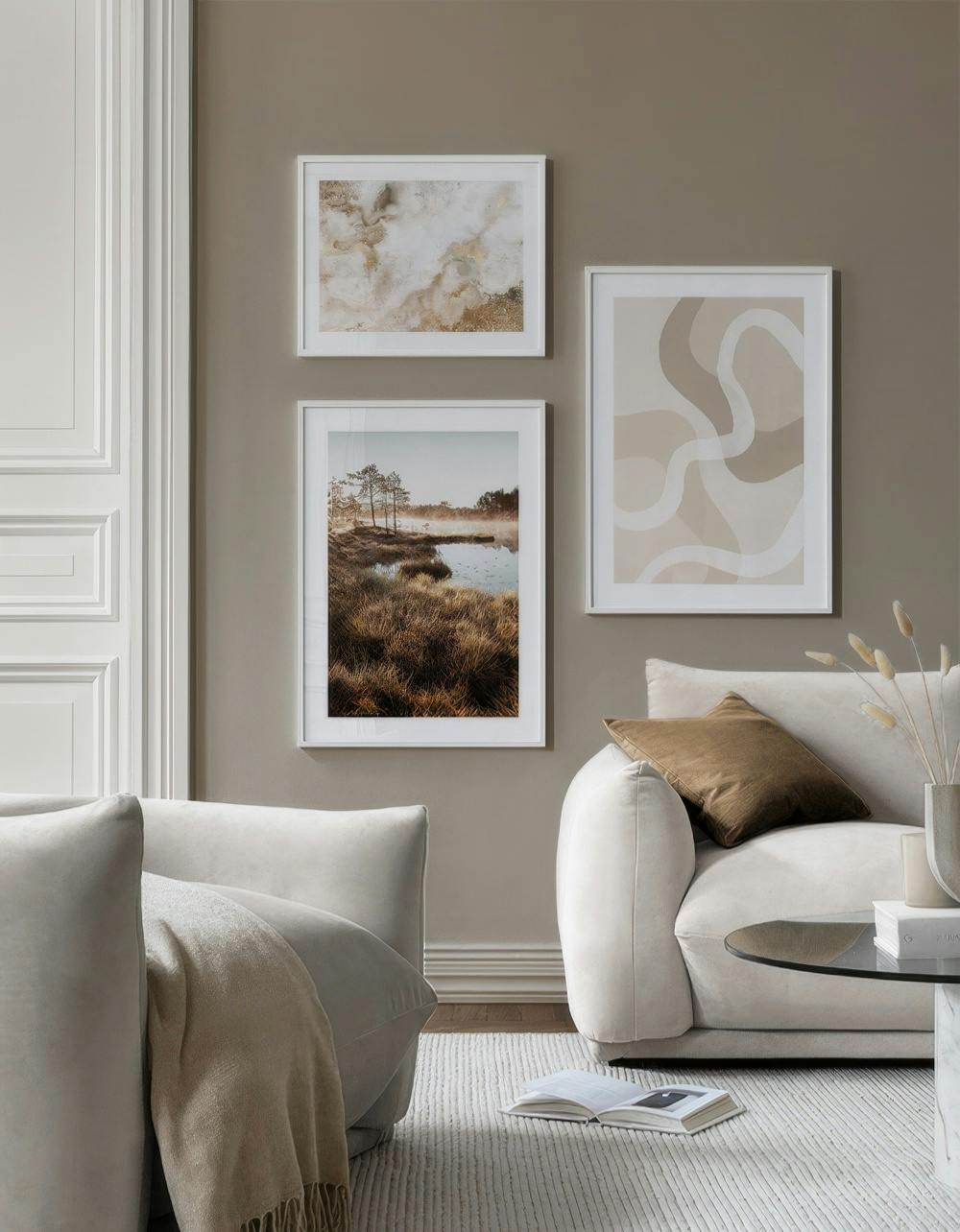 A gallery wall with three prints: a gold and white marble texture, a misty landscape with trees and water, and a neutral abstrac