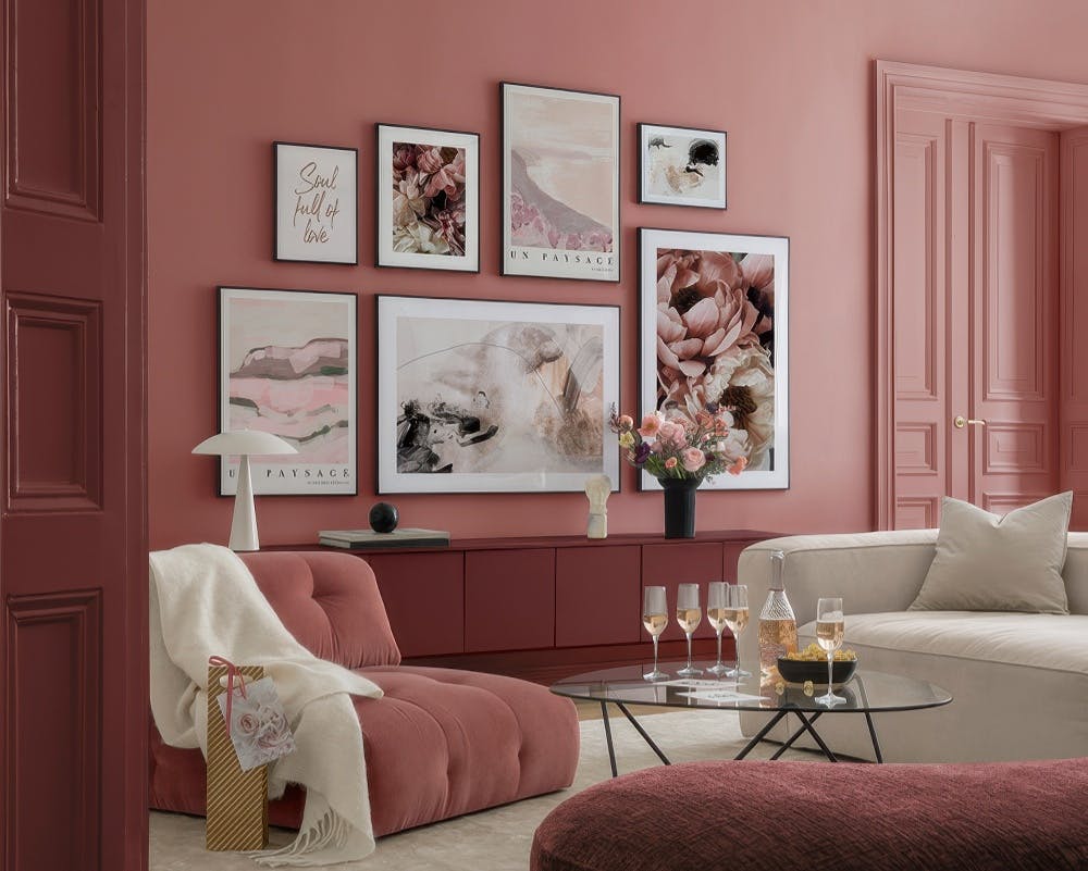 Décoration murale avec des affiches roses et beiges, incluant des paysages abstraits, des motifs floraux et des citations.
