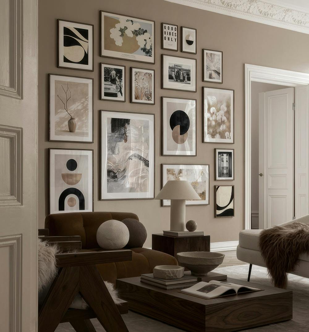 Een galeriewand met abstracte prints in crème, beige en bruin, inclusief botanische en geometrische vormen, in een woonkamer.