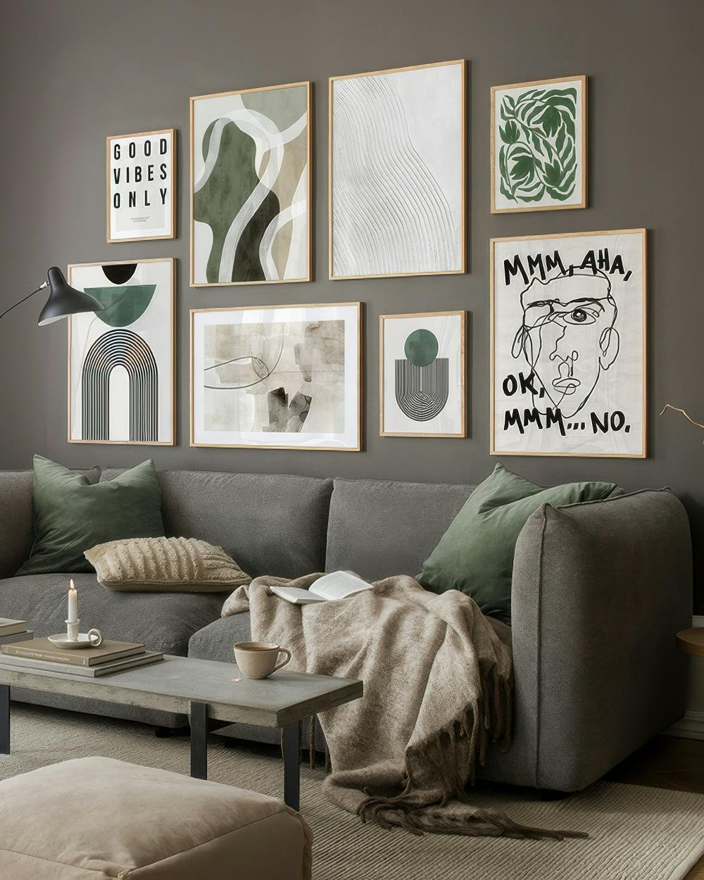 En bildevegg med plakater med grønne og beige abstrakte motiver, svart-hvitt grafikk og illustrasjoner.