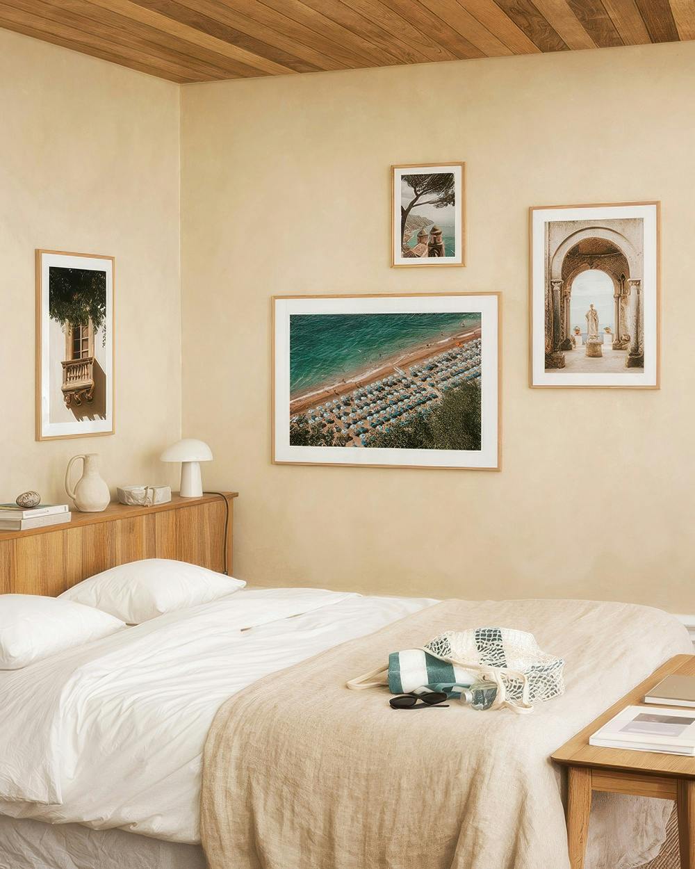Galleria a parete con stampe tra cui una finestra mediterranea, una spiaggia dallalto e un arco antico.