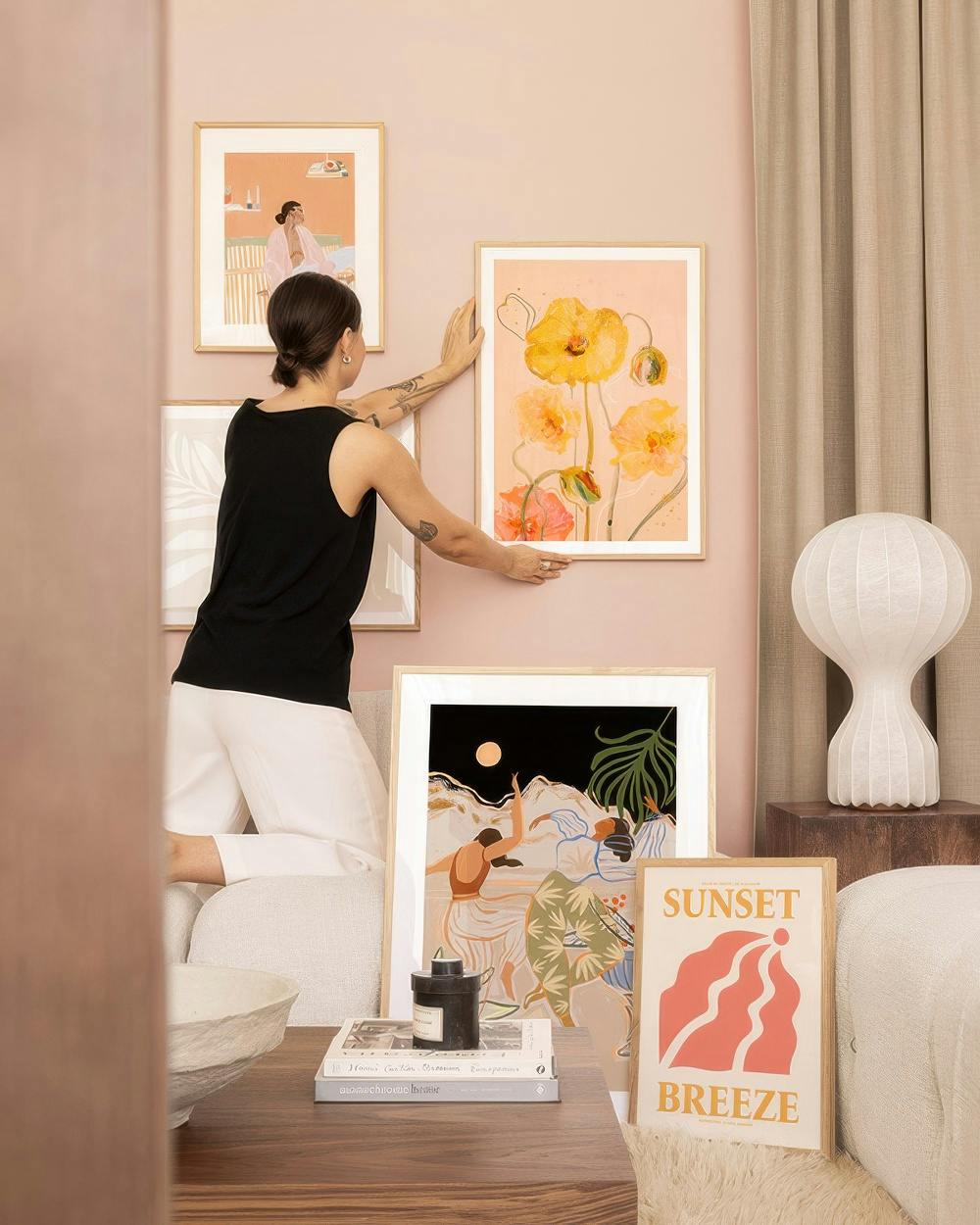 Une décoration murale avec une femme installant un tableau de coquelicots jaunes et une scène de danseurs au clair de lune.