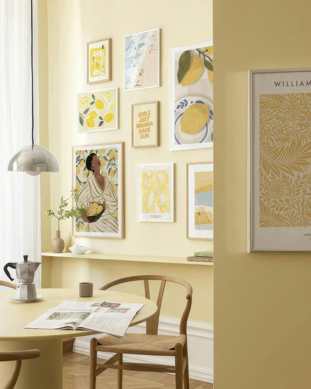 A gallery wall with various lemon-themed prints, a beach scene, abstract art, and a woman holding lemons on a light yellow wall.