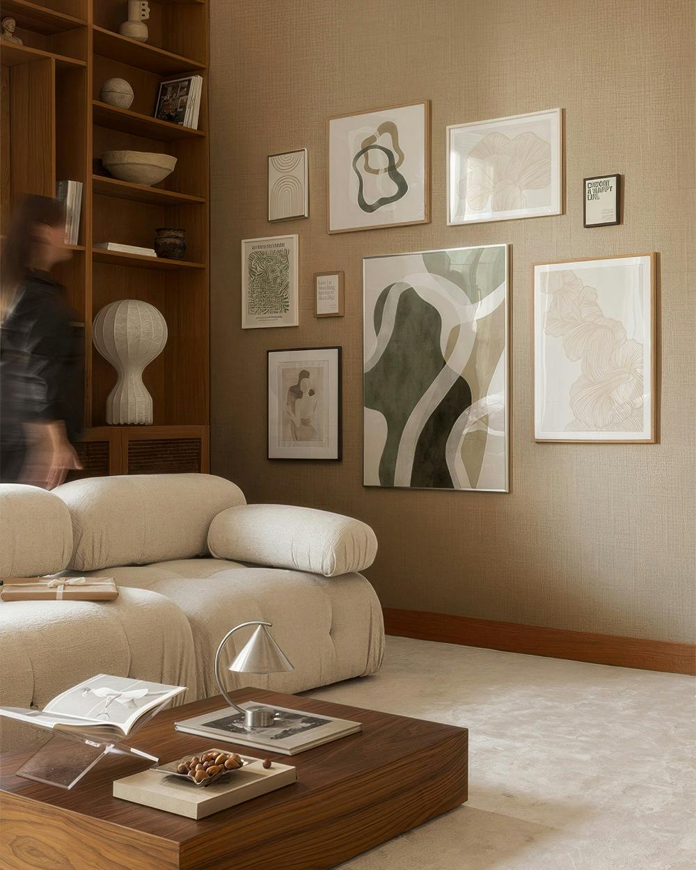 A gallery wall with various abstract prints in earthy tones, including organic shapes, flowing lines, and subtle botanical patte